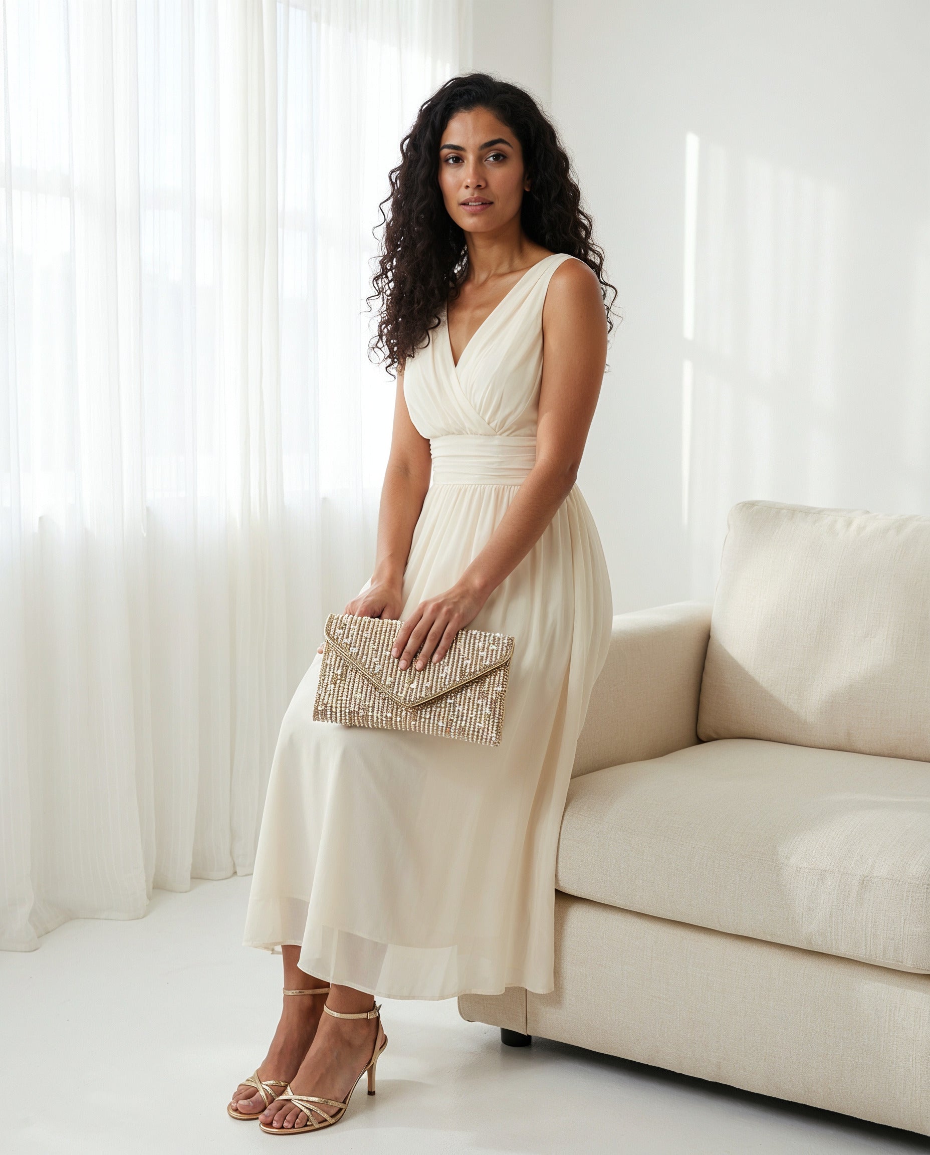 Woman with the Gold Perlette Pearl & Crystal Envelope Clutch in a bright airy interior