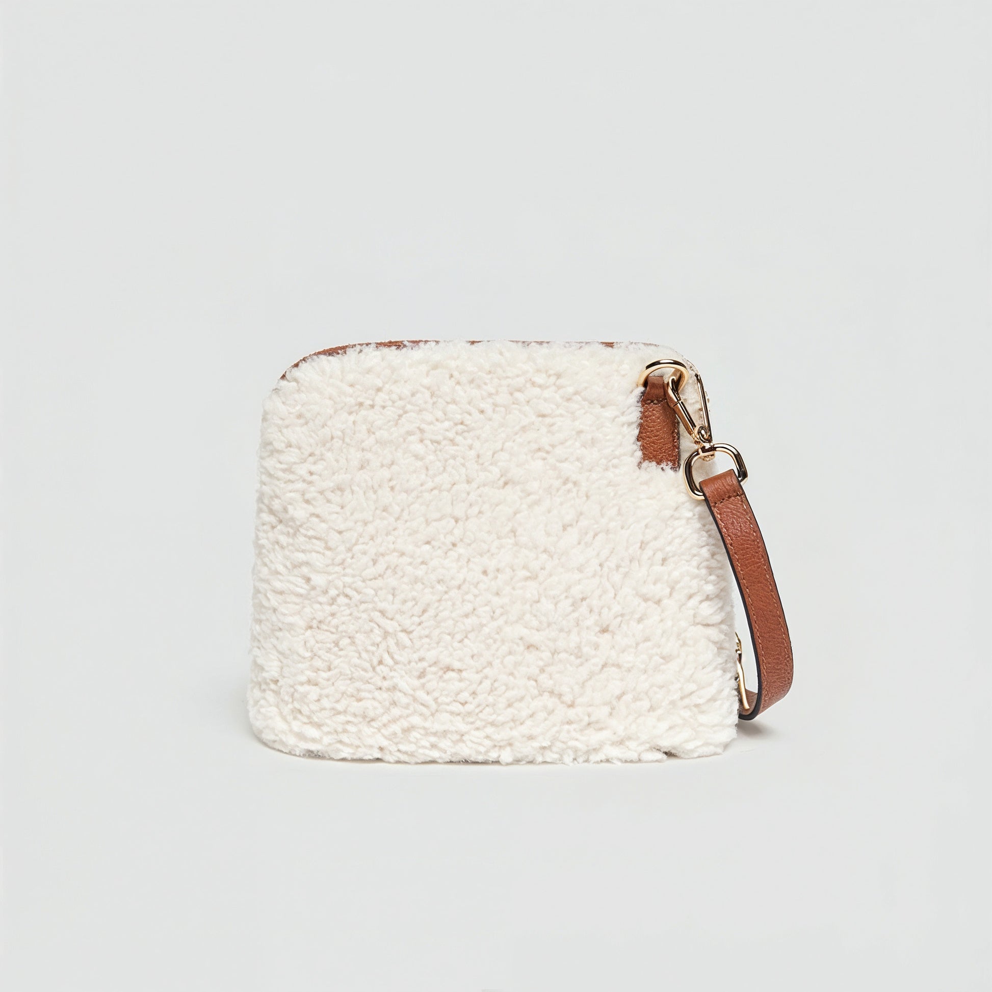 Zita faux shearling crossbody bag in ivory on a light grey studio background