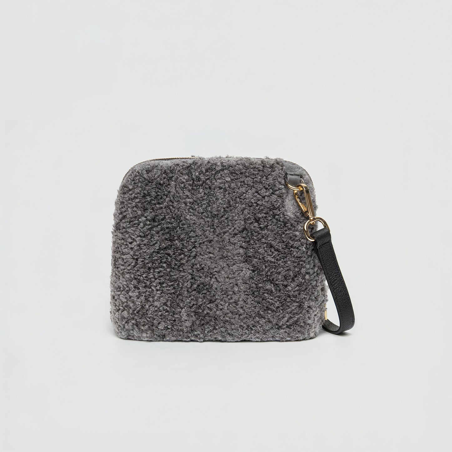 Zita faux shearling crossbody bag in grey on a light grey studio background