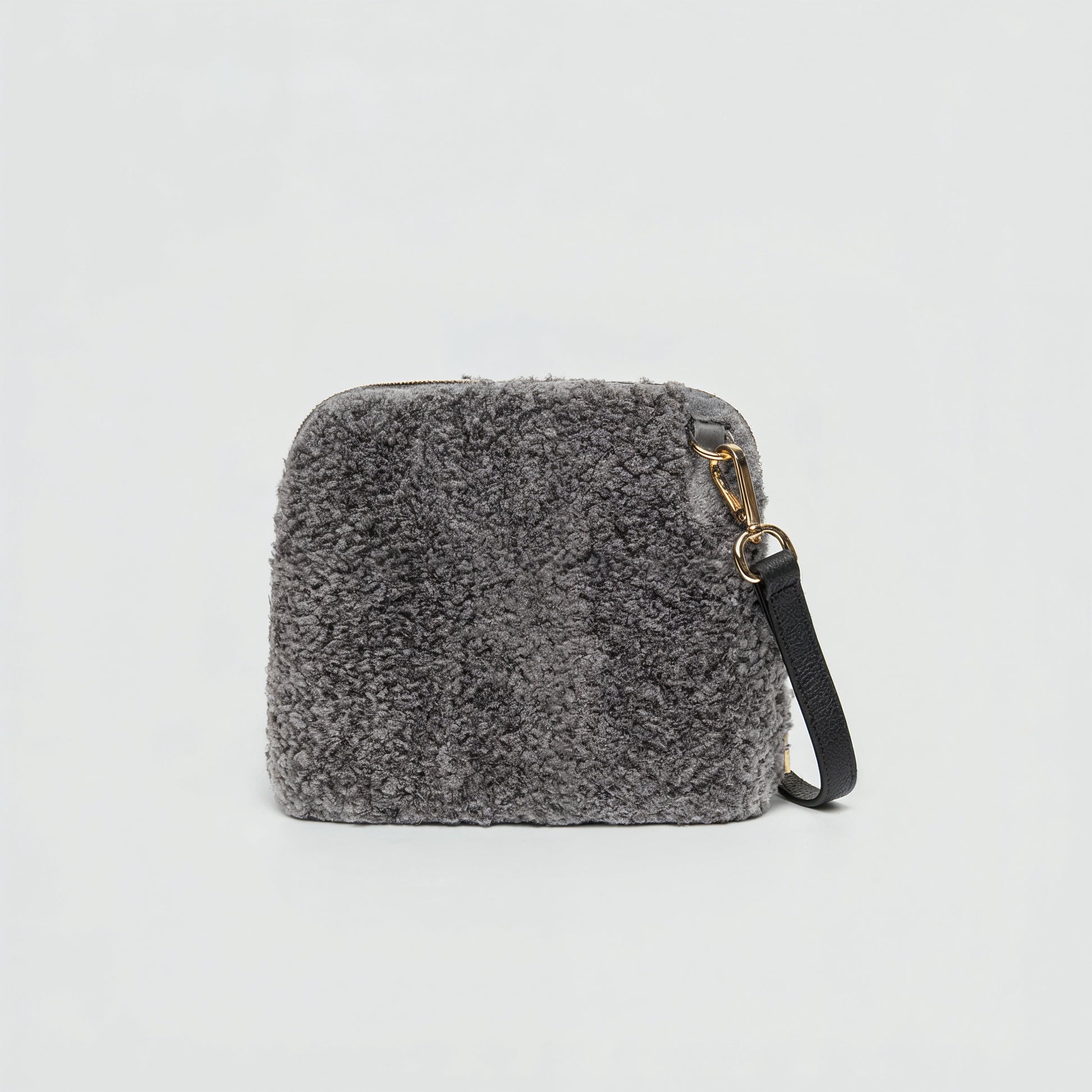 Zita faux shearling crossbody bag in grey on a light grey studio background