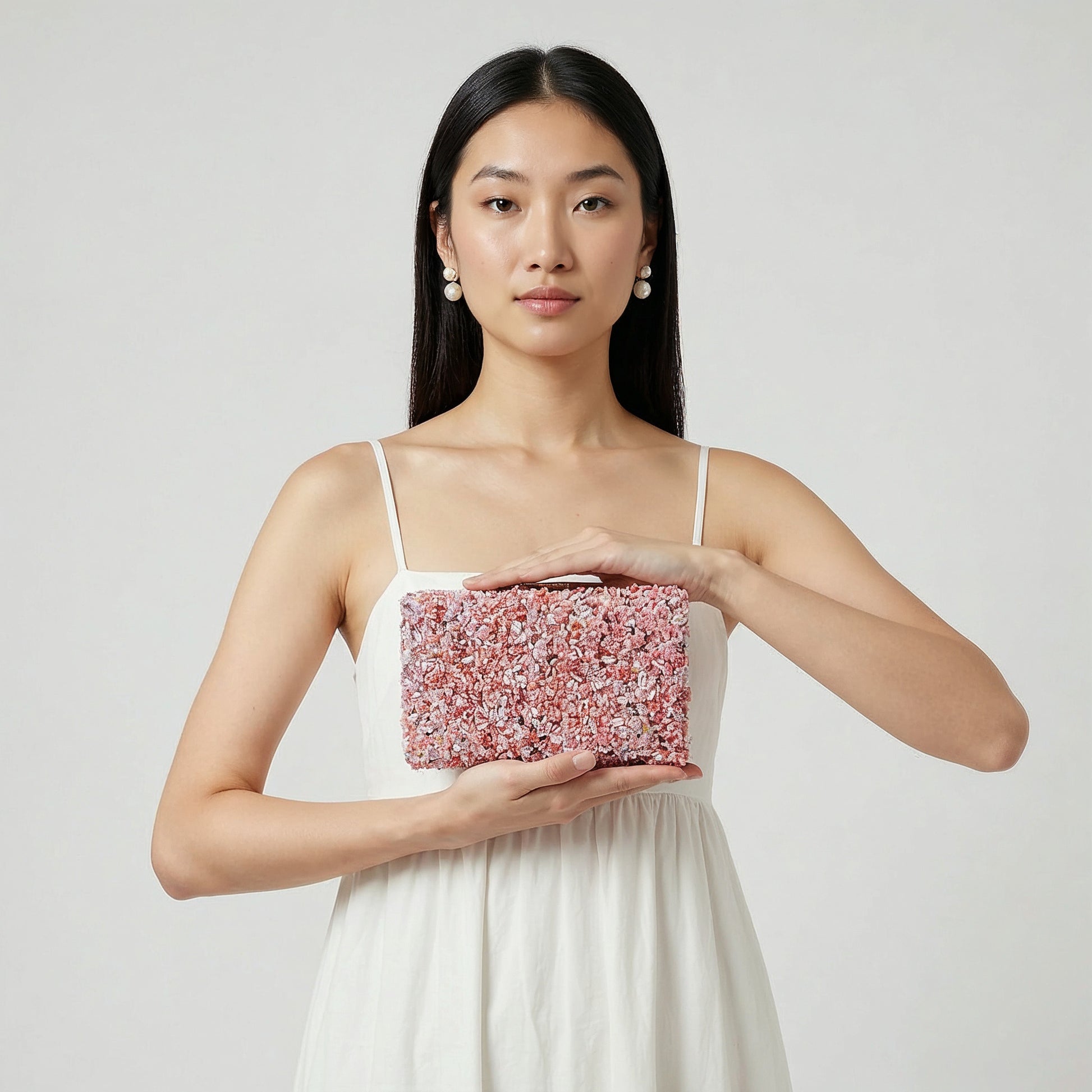 Model presenting the Lilac Gemma Natural Stone Box Clutch on her open palm, studio shot