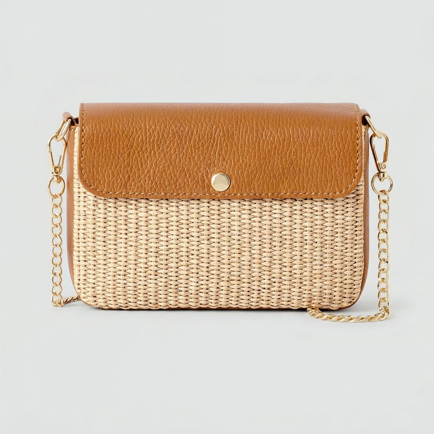 Élodie raffia and leather flap crossbody bag in tan on a light grey studio background