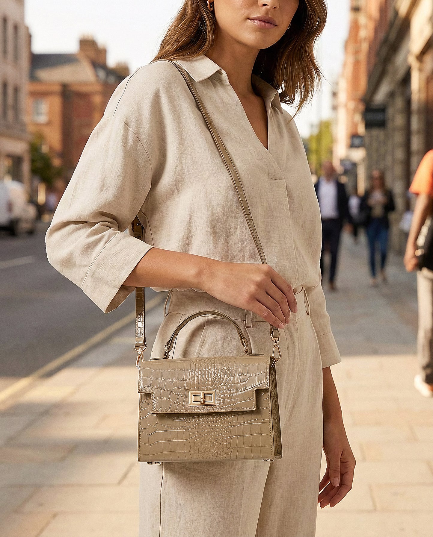 Woman with the Light Taupe Margot Croc crossbody bag on a sunlit city street