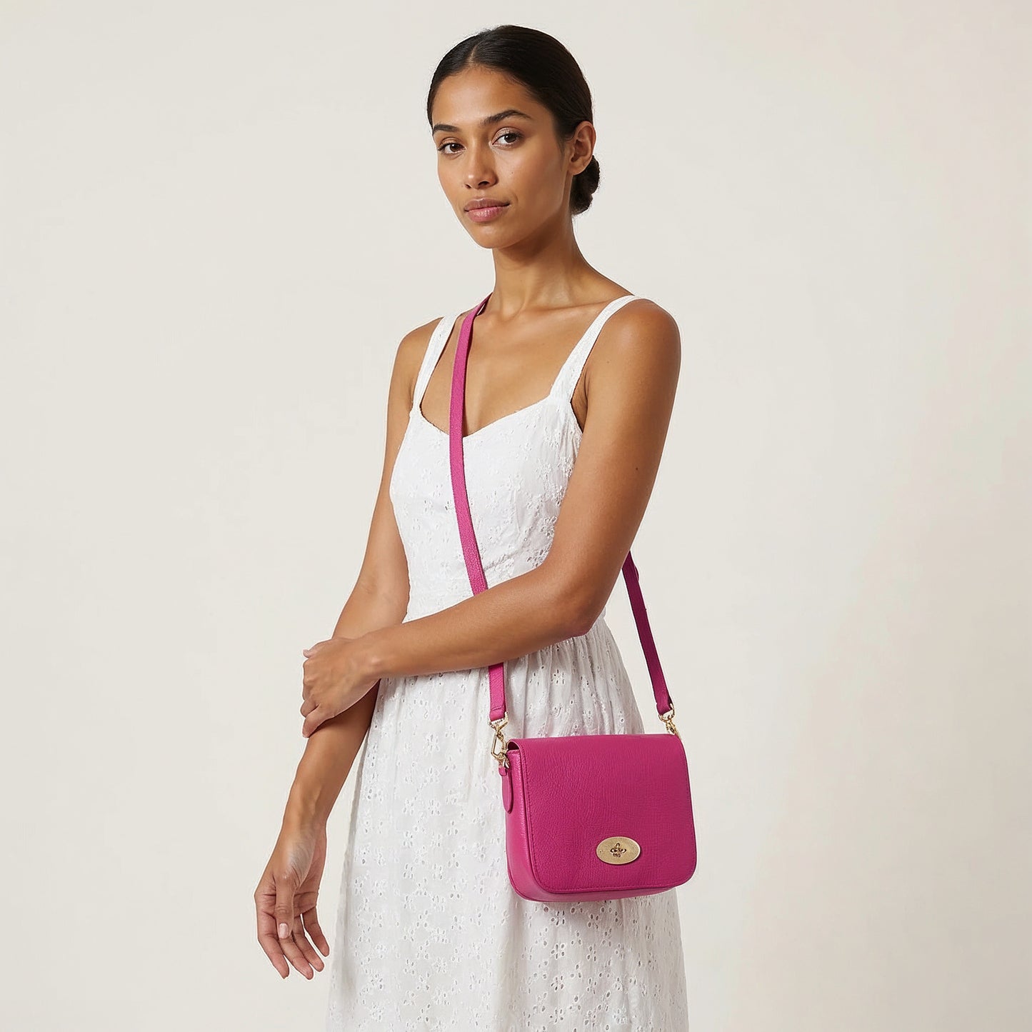 Model carrying the Fuchsia Chiara crossbody bag on her arm, studio shot