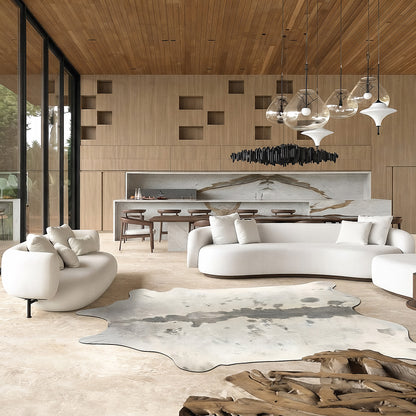 Ivory cowhide rug with grey dorsal stripe styled on the floor of a bright loft living room