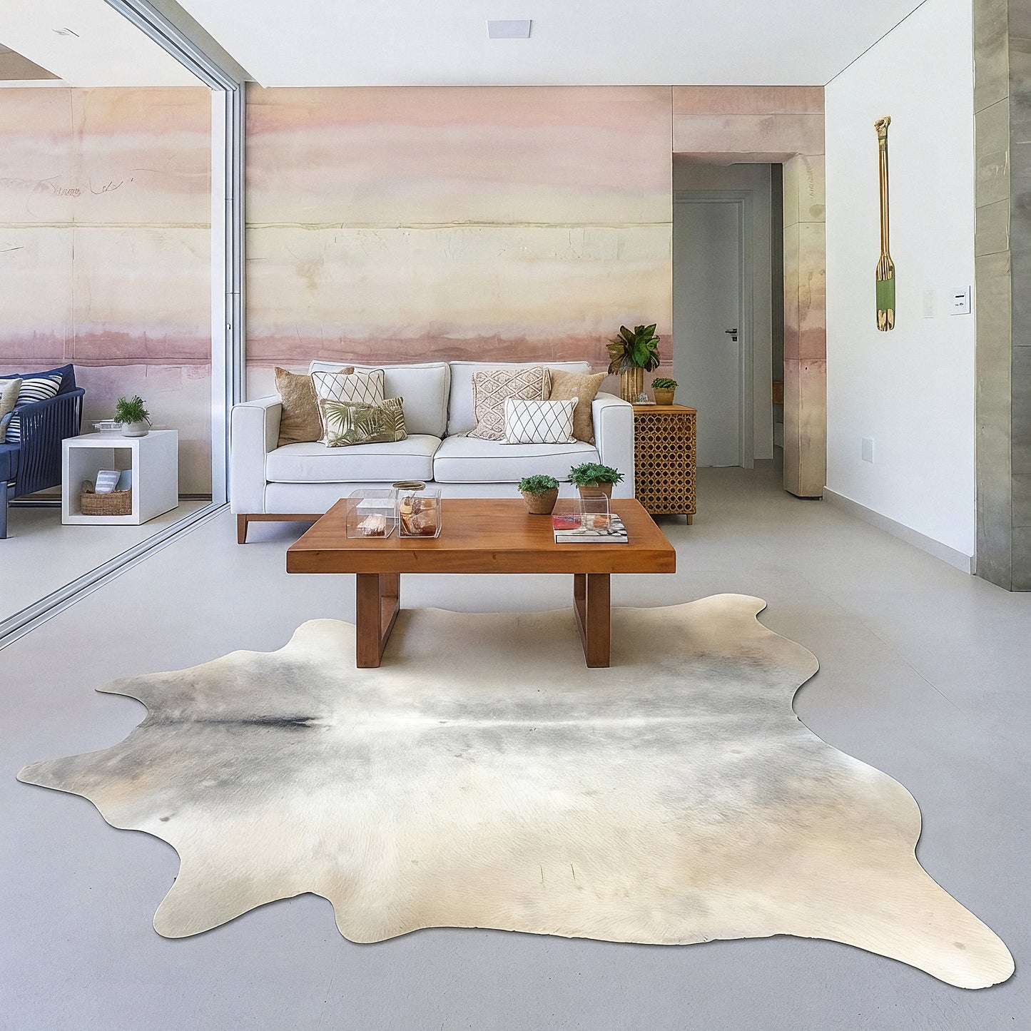 Pale cream cowhide rug in a soft blush-pink living room