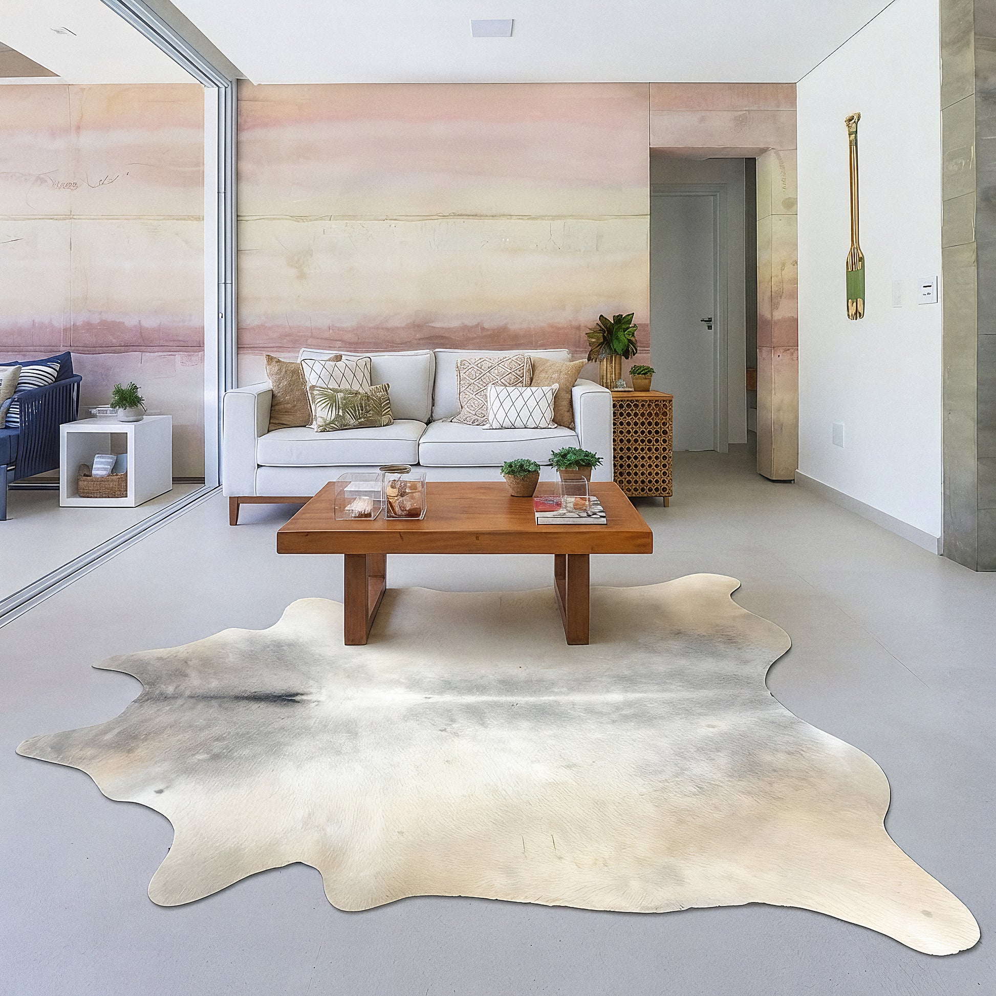 Pale cream cowhide rug in a soft blush-pink living room