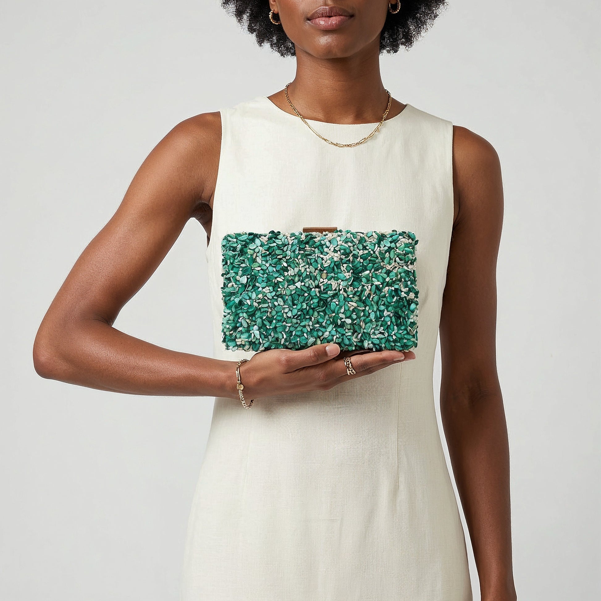 Model presenting the Turquoise Gemma Natural Stone Box Clutch on her open palm, studio shot