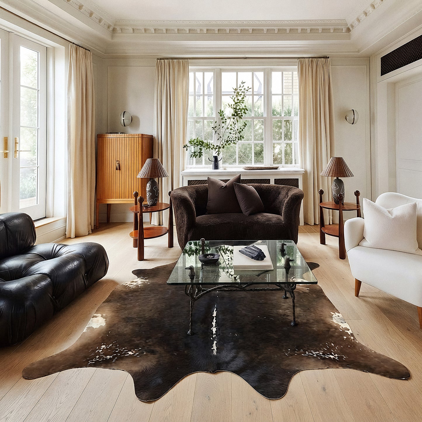 Espresso solid cowhide rug styled on the floor of an elegant cream living room