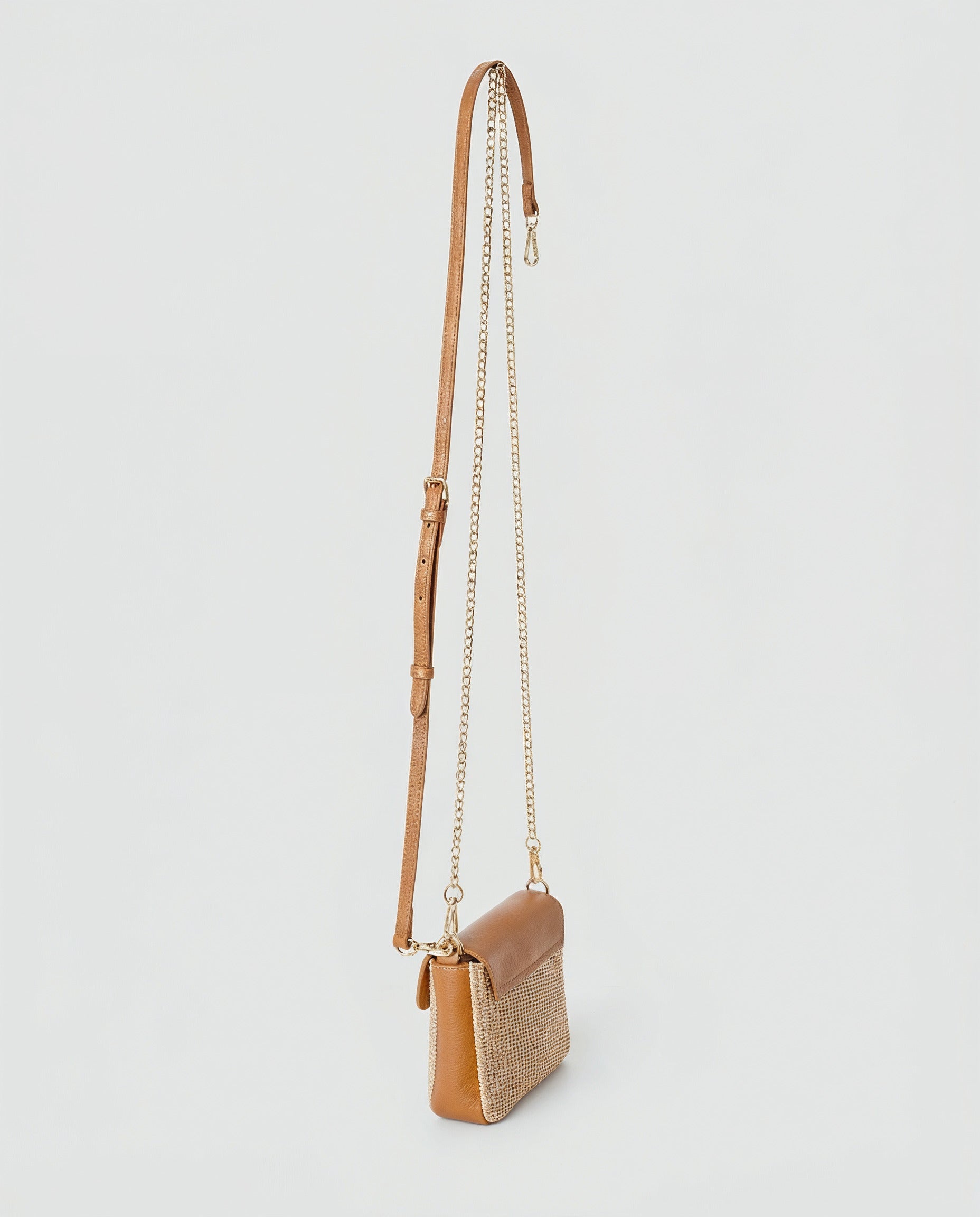 Élodie raffia and leather flap crossbody bag with crossbody strap, light grey studio background