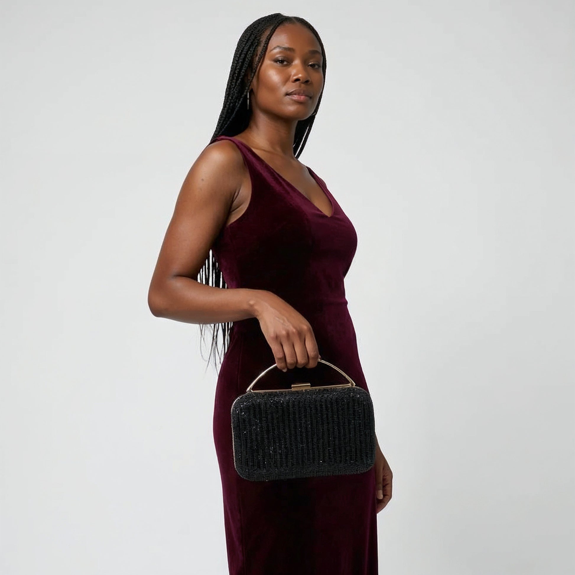 Model with the Black Odette Crystal Minaudière Clutch dangling from her fingers, studio shot