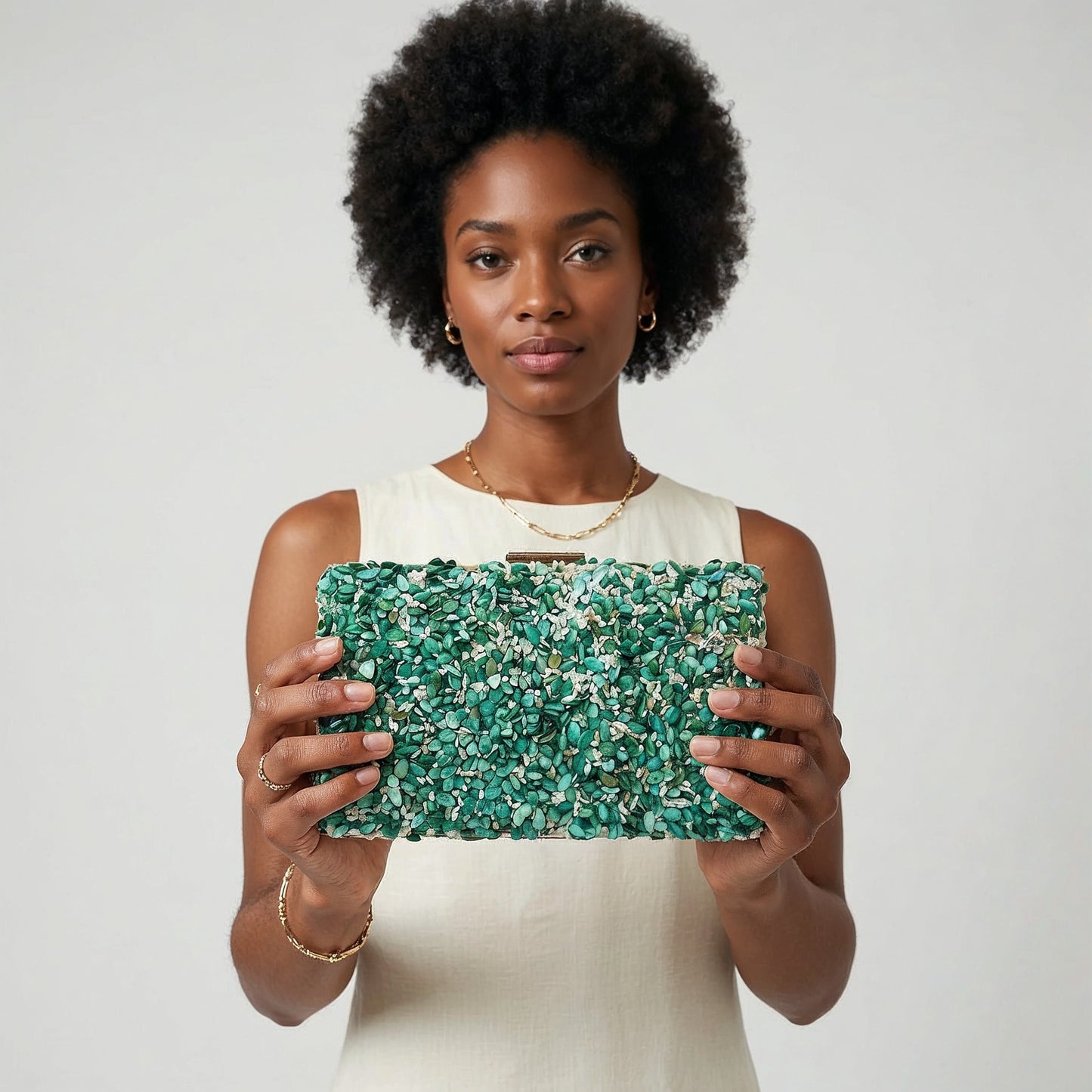 Model presenting the Turquoise Gemma Natural Stone Box Clutch to the camera, studio hero shot