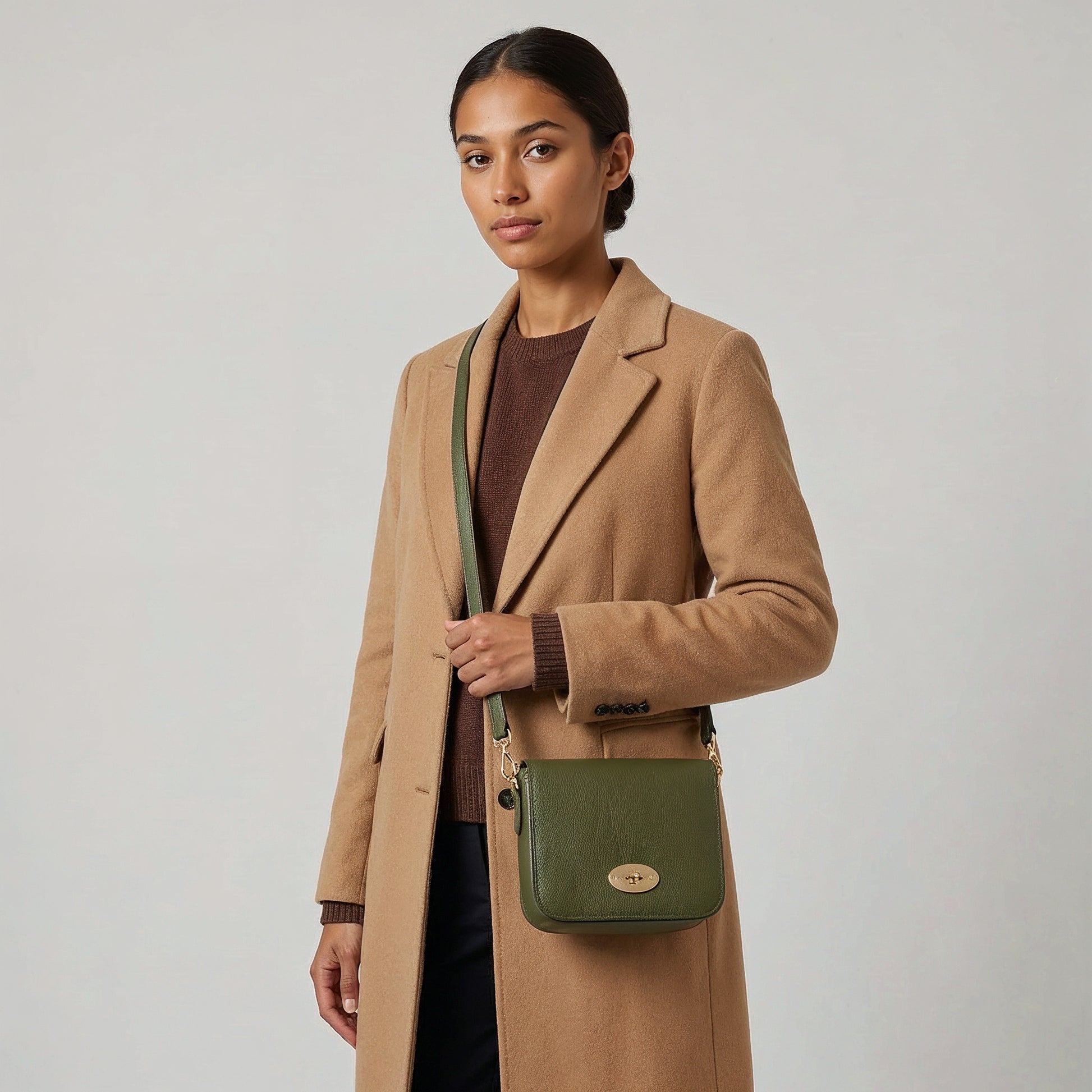 Model with the Dark Olive Chiara crossbody bag at her hip, studio shot