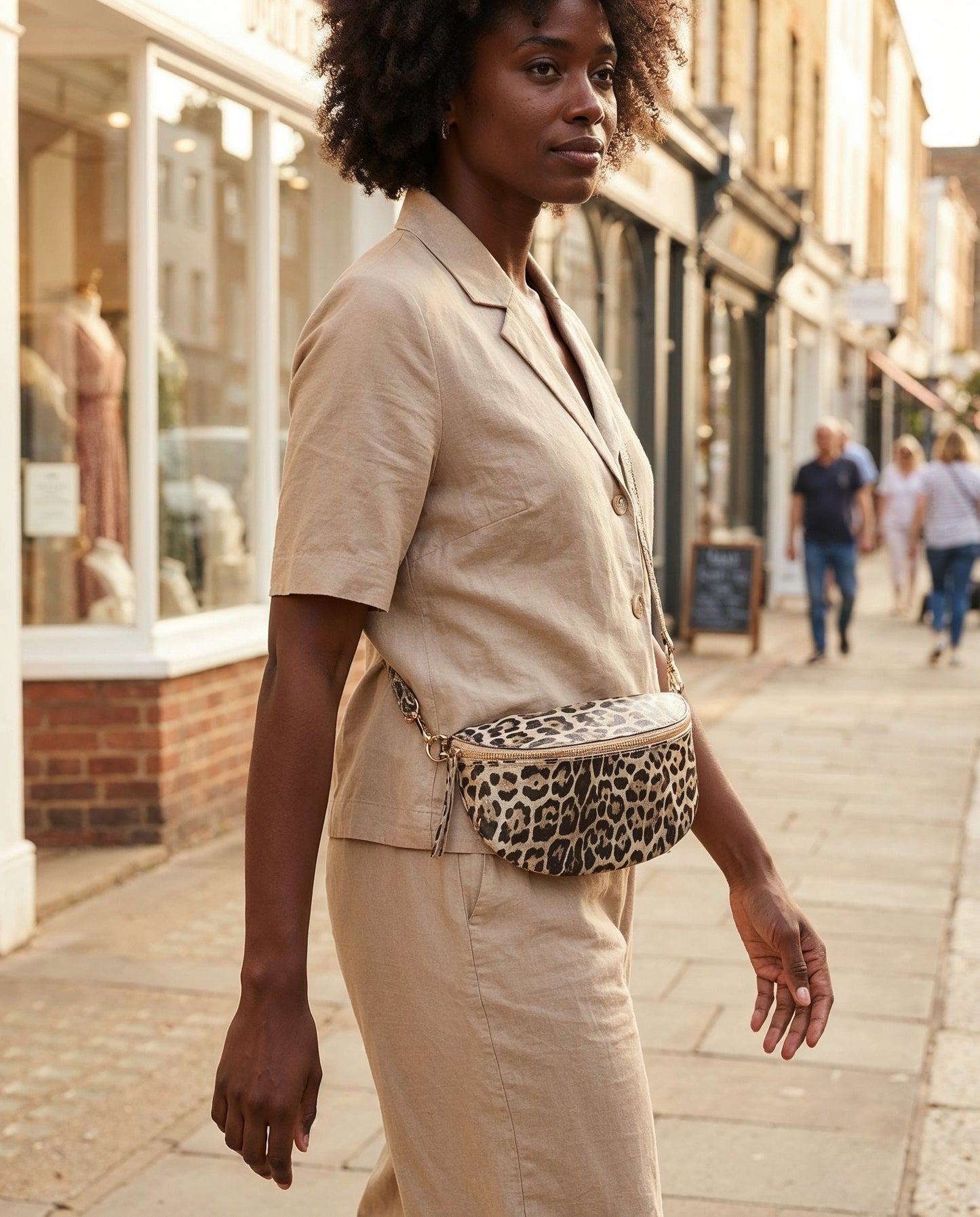 Woman wearing the Light Gold Leopard Romy bum bag on a sunlit shopping street