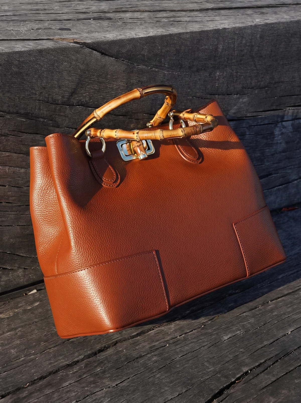 Ginevra Bamboo-Handle Leather Bag by Clemés in Cognac, studio shot on dark wood