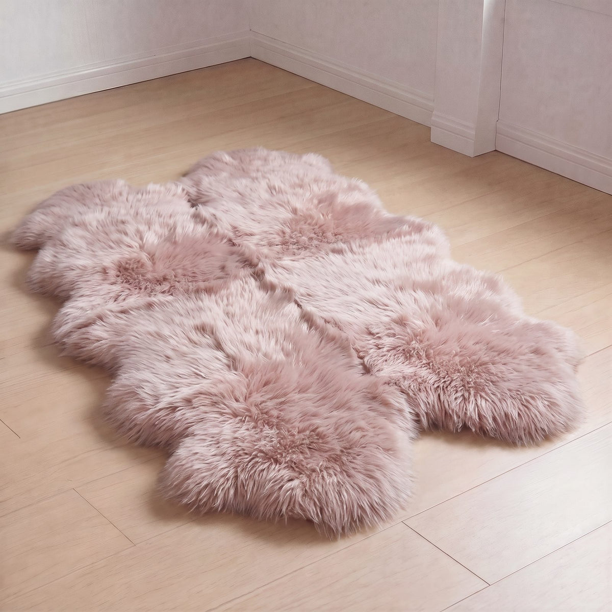 Light Rose quad sheepskin rug laid on a light wood floor