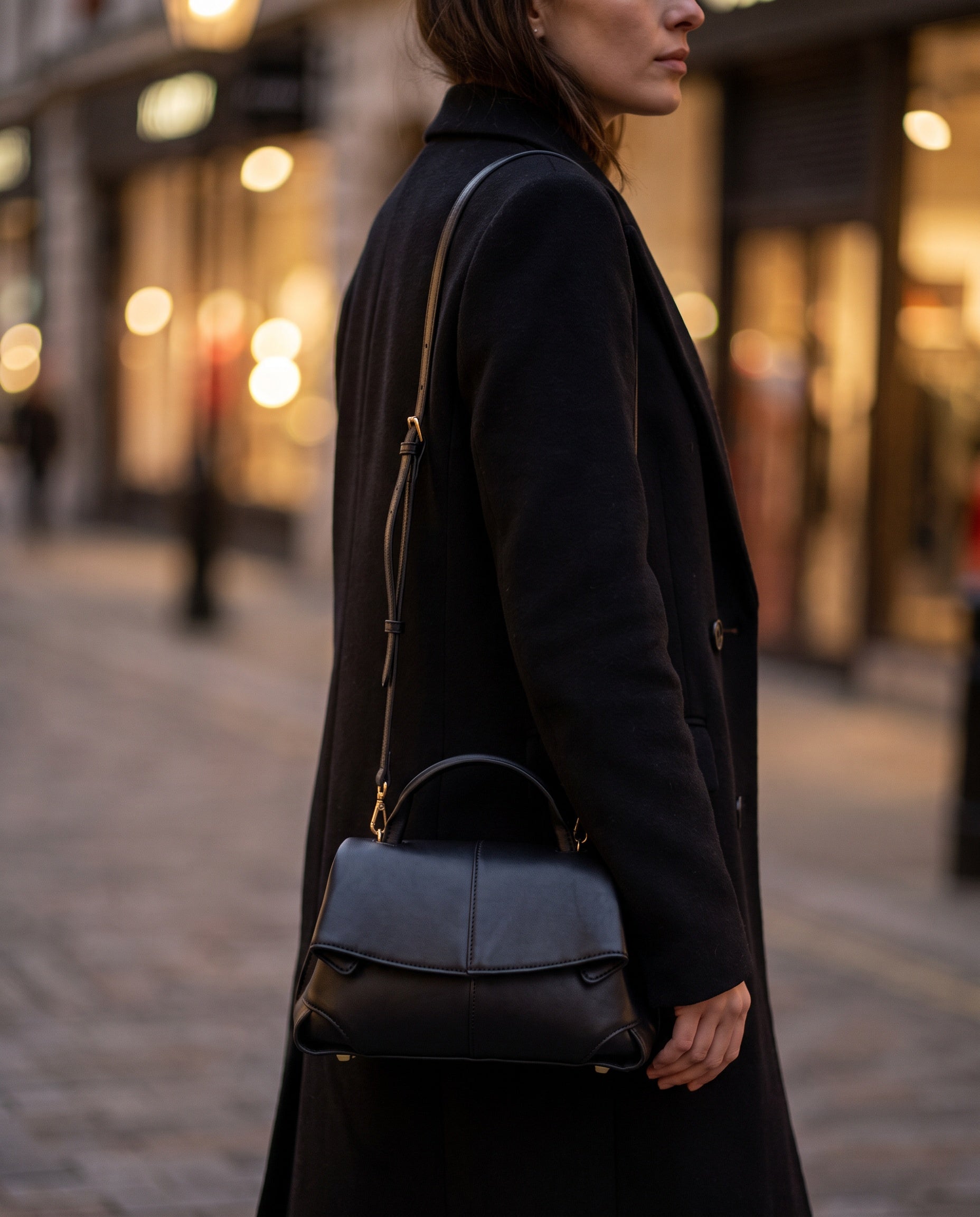 Woman with the Black Fiorella bag crossbody on an evening city street