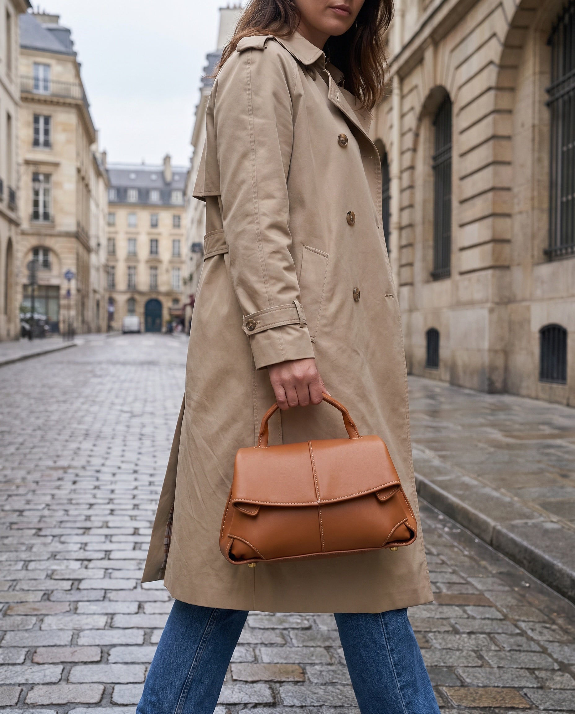 Woman holding the Cognac Fiorella bag on an overcast city street