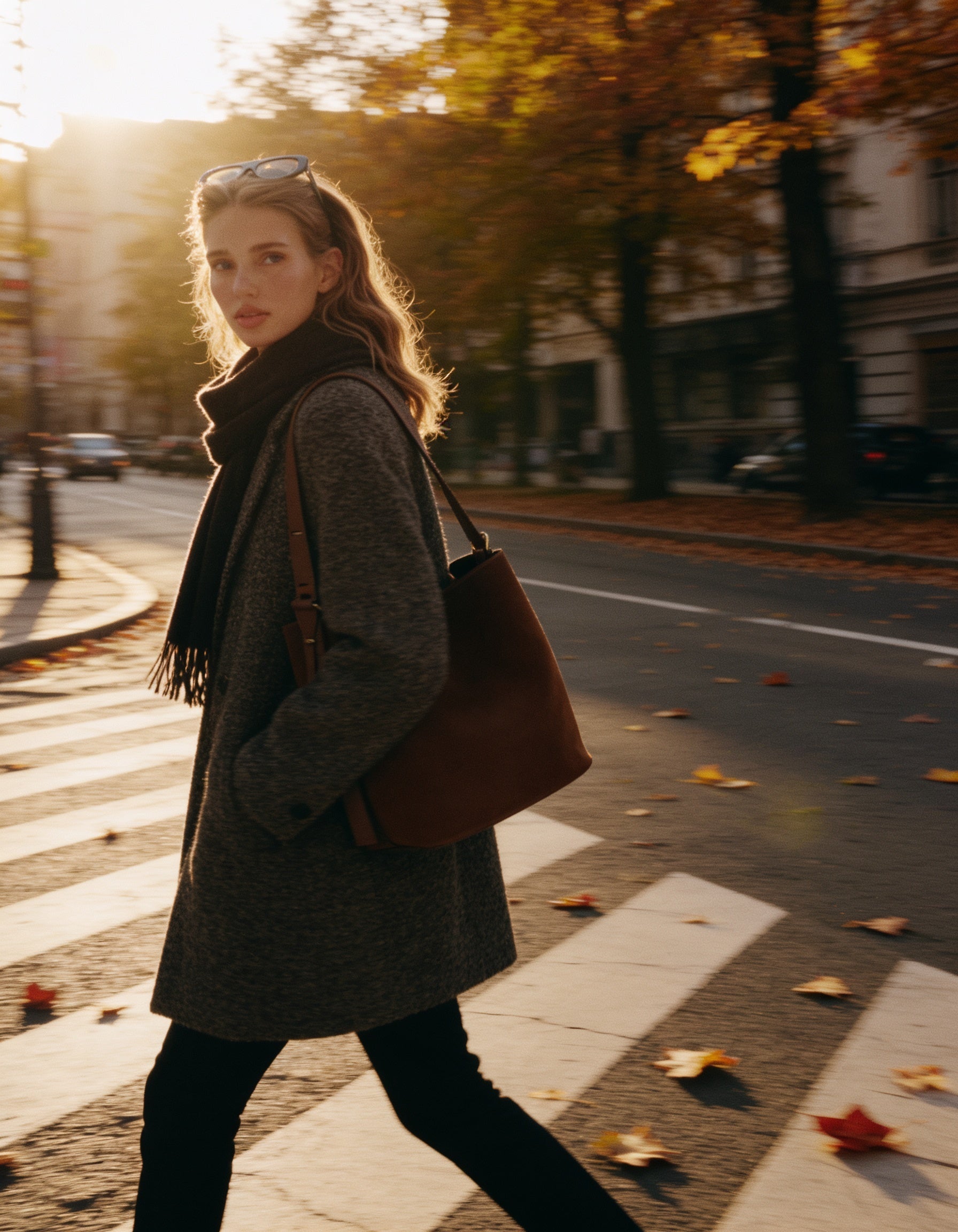 Woman wearing the Chocolate Serena bucket bag, walking across a street