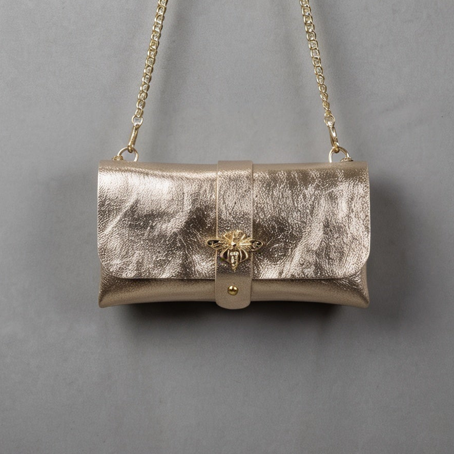 Anima Suede Leather Metallic Clutch Shoulder Bag by Clemés in Champagne, three-quarter studio shot on grey background