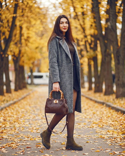 Woman with the Medium Ginevra bamboo-handle leather bag in Dark Brown on an autumn street