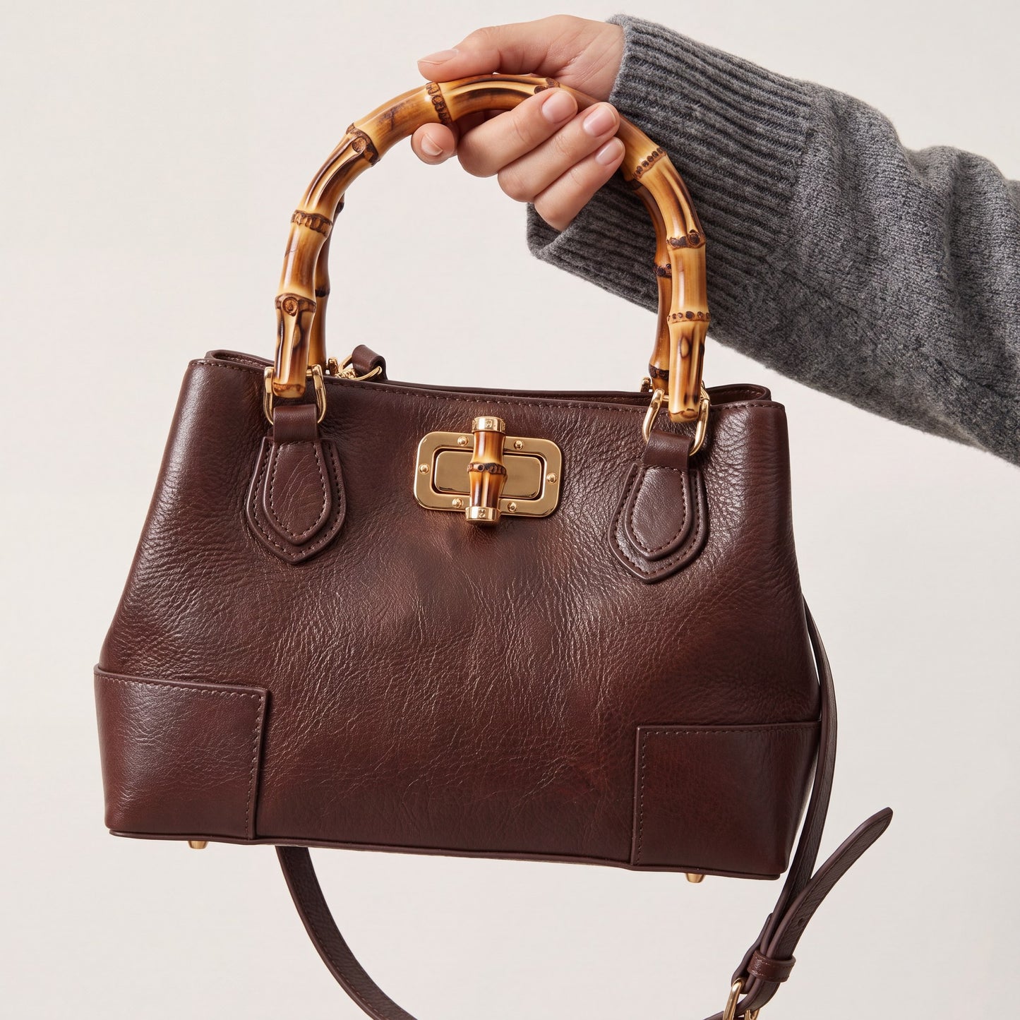Model carrying the Medium Ginevra bamboo-handle leather bag in Dark Brown, studio shot