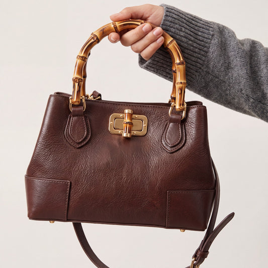 Model carrying the Medium Ginevra bamboo-handle leather bag in Dark Brown, studio shot