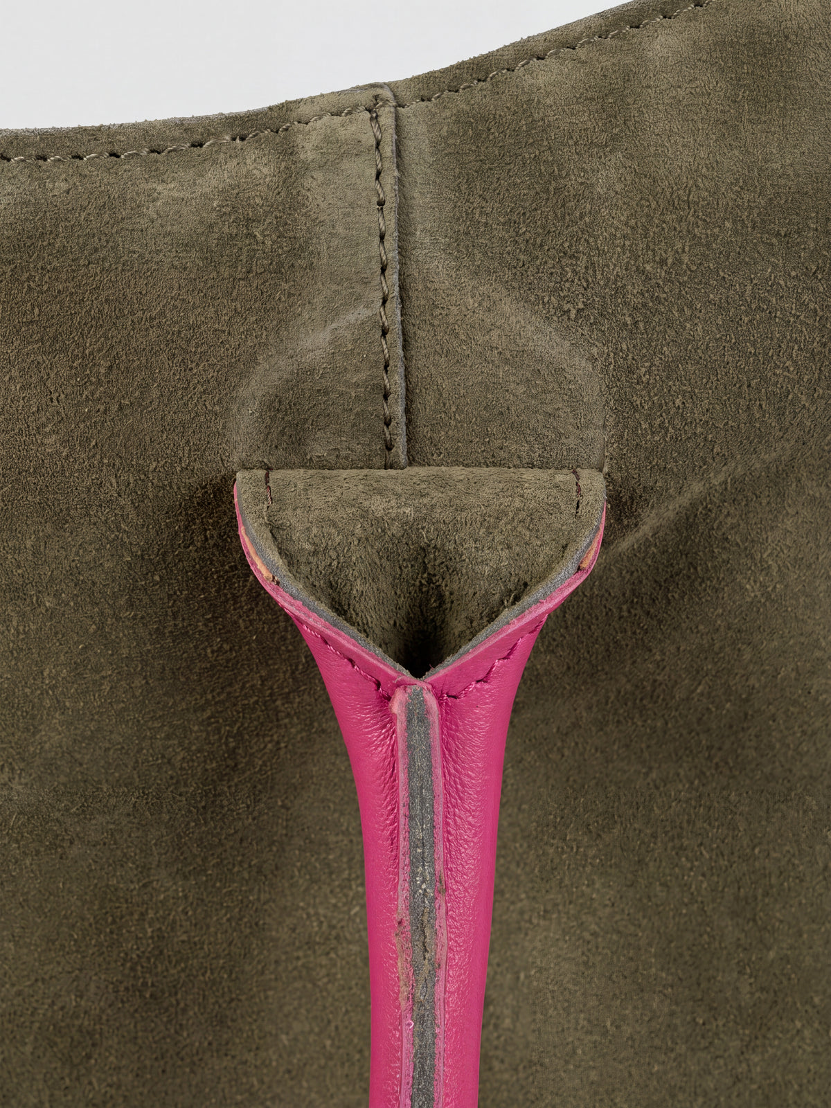 Milano Max Suede Bag in Olive by Clemés, macro detail of the olive suede gusset where the pink handle is anchored