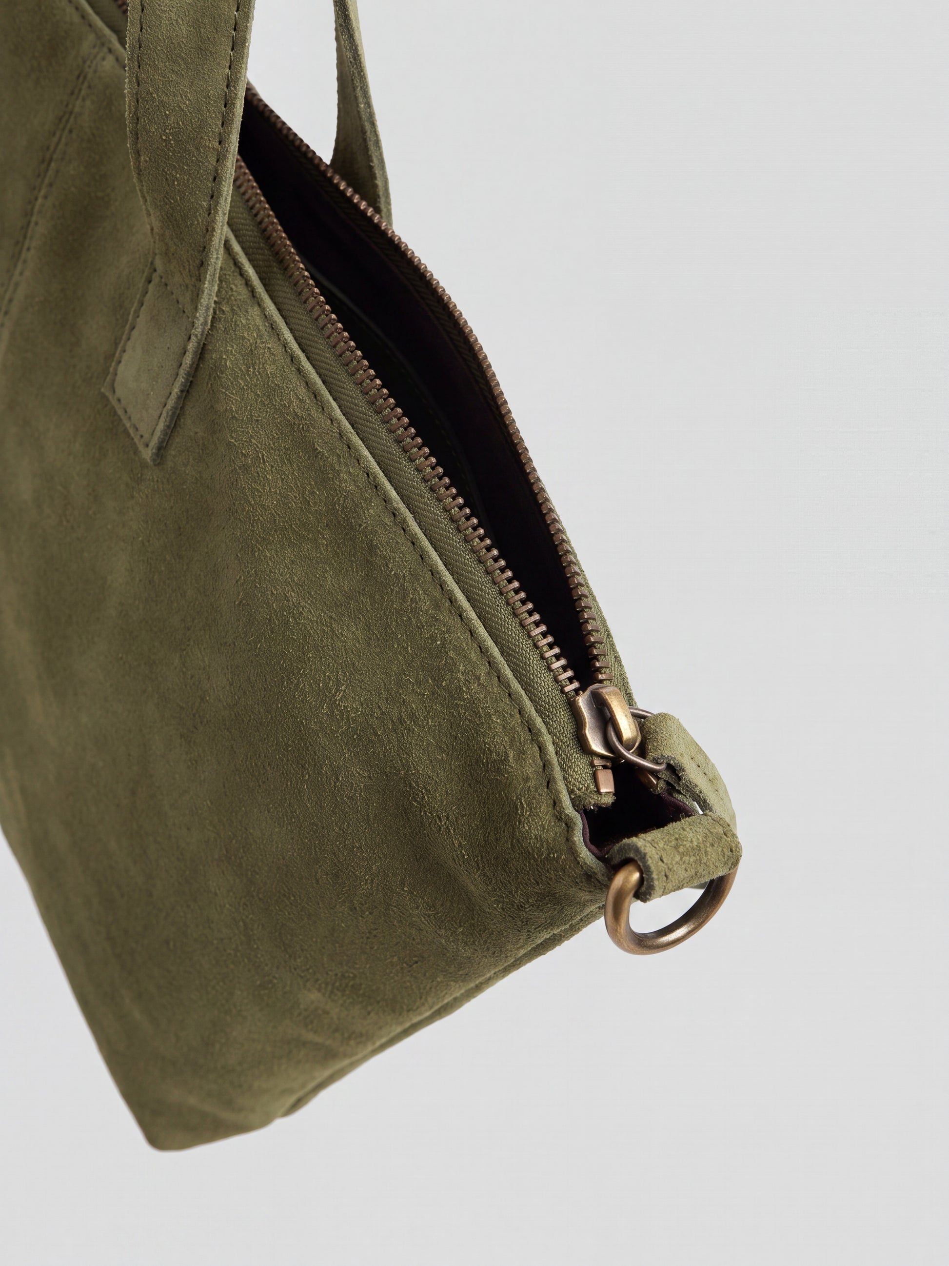 Milano Max Suede Bag in Olive by Clemés, close-up of the zip end with antique brass slider and D-ring on the suede tab