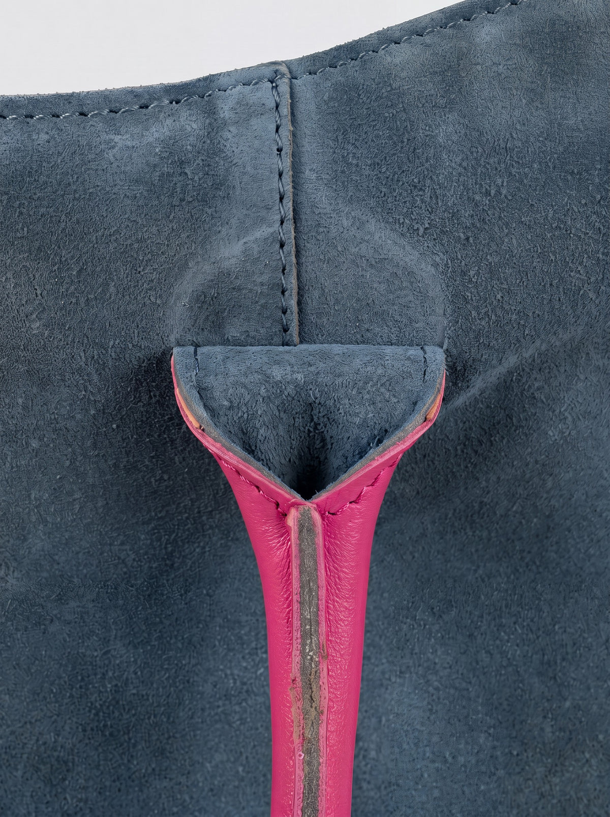Milano Max Suede Bag in Blue by Clemés, macro detail of the blue suede gusset where the pink handle is anchored
