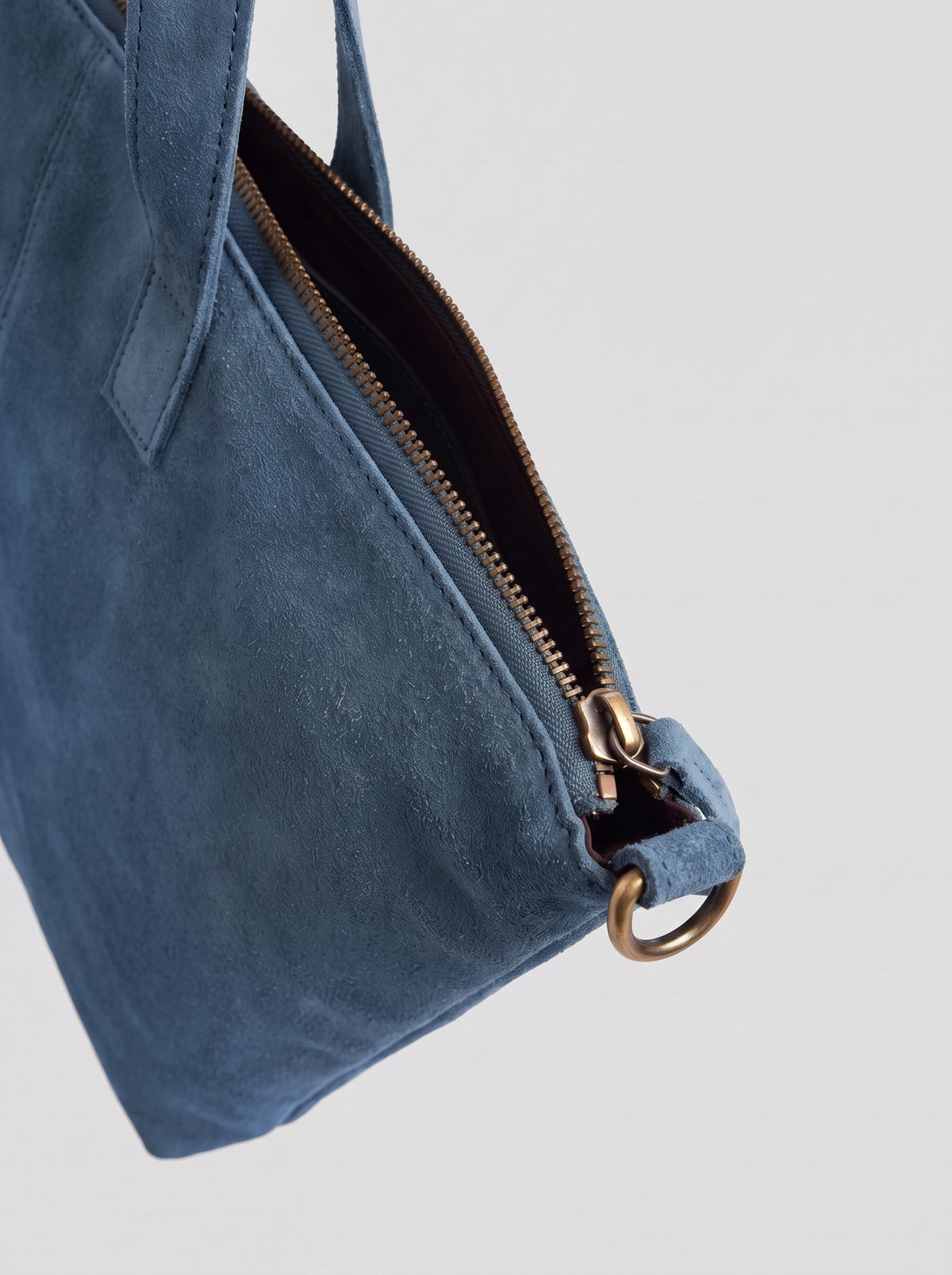 Milano Max Suede Bag in Blue by Clemés, close-up of the zip end with antique brass slider and D-ring on the blue suede tab