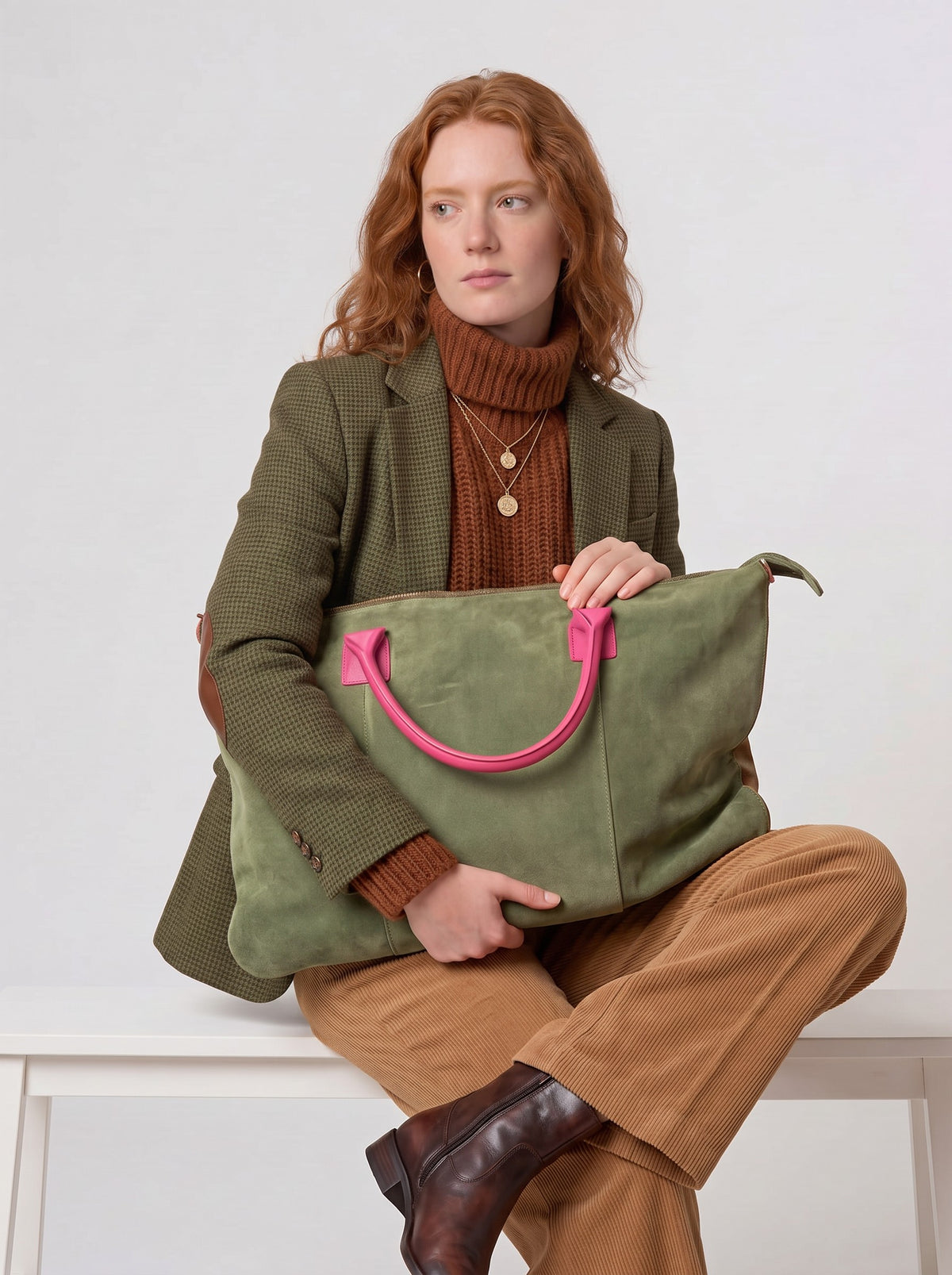 Model in a tweed blazer looking off camera, hugging the Olive Milano Max Suede Bag by Clemés on her lap