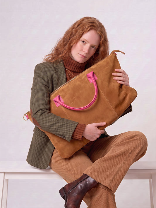 Model hugging the Tan Milano Max Suede Bag by Clemés, showing its large slouchy size