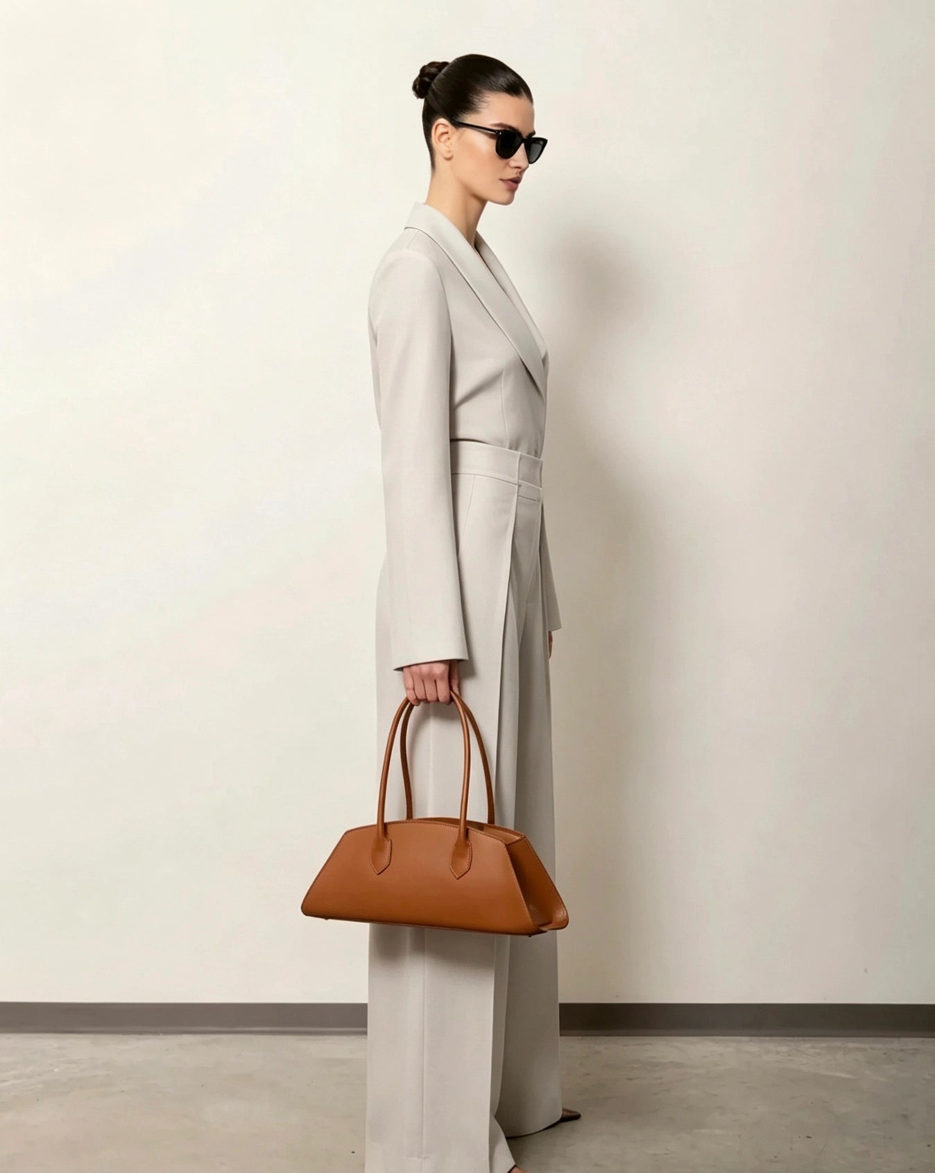 Model carrying the Nora Calfskin Shoulder Bag by Clemés in Cognac, street style