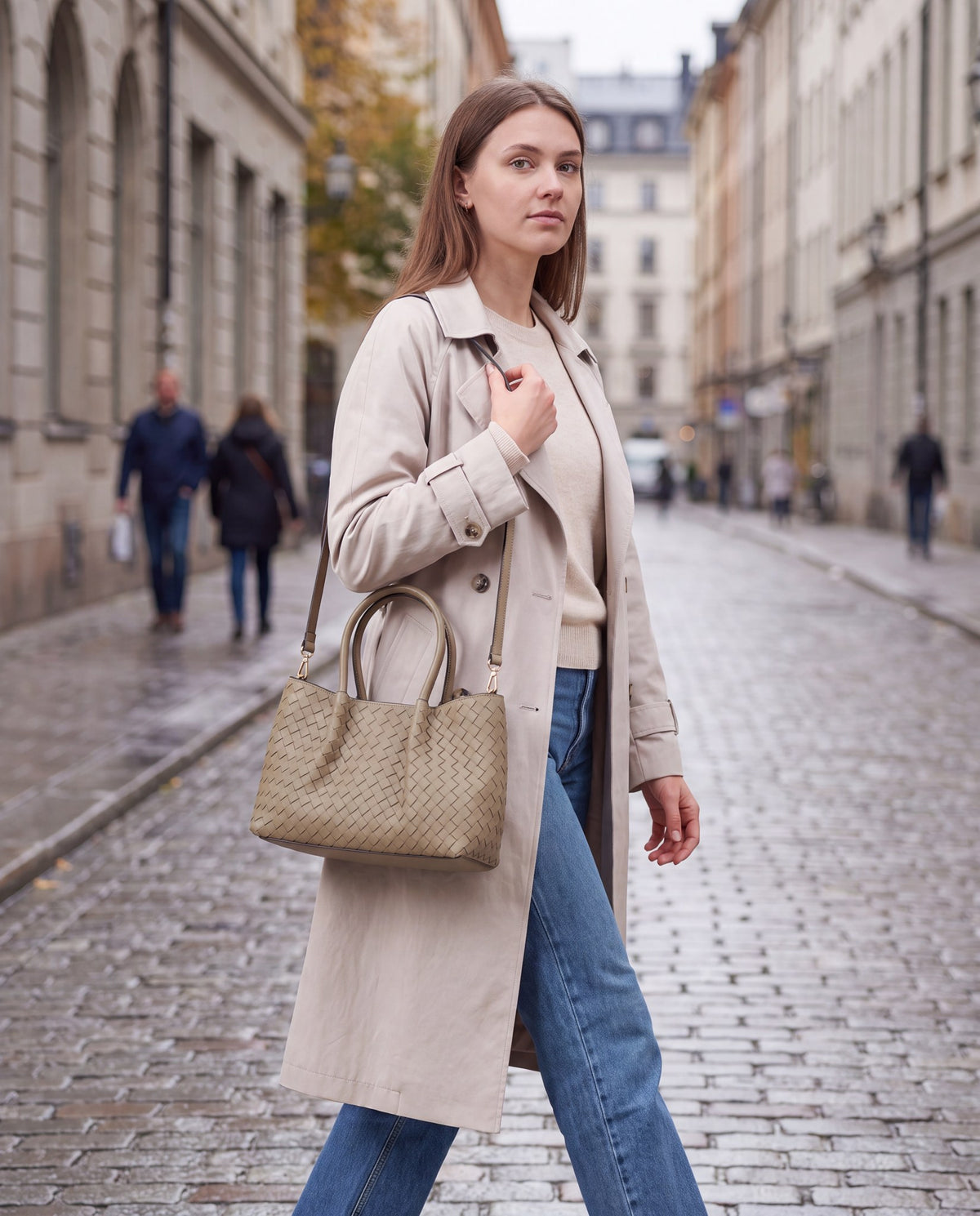 Woman with the Taupe Ornella woven leather bag on an overcast city street