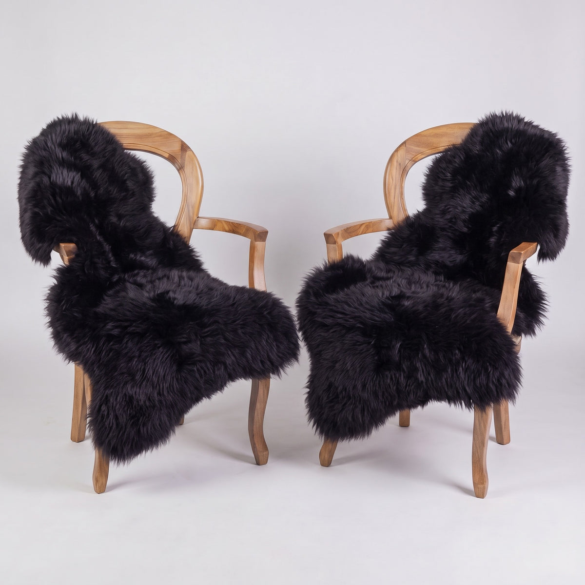 Pair of Black X-Large single sheepskin rugs draped over two armchairs