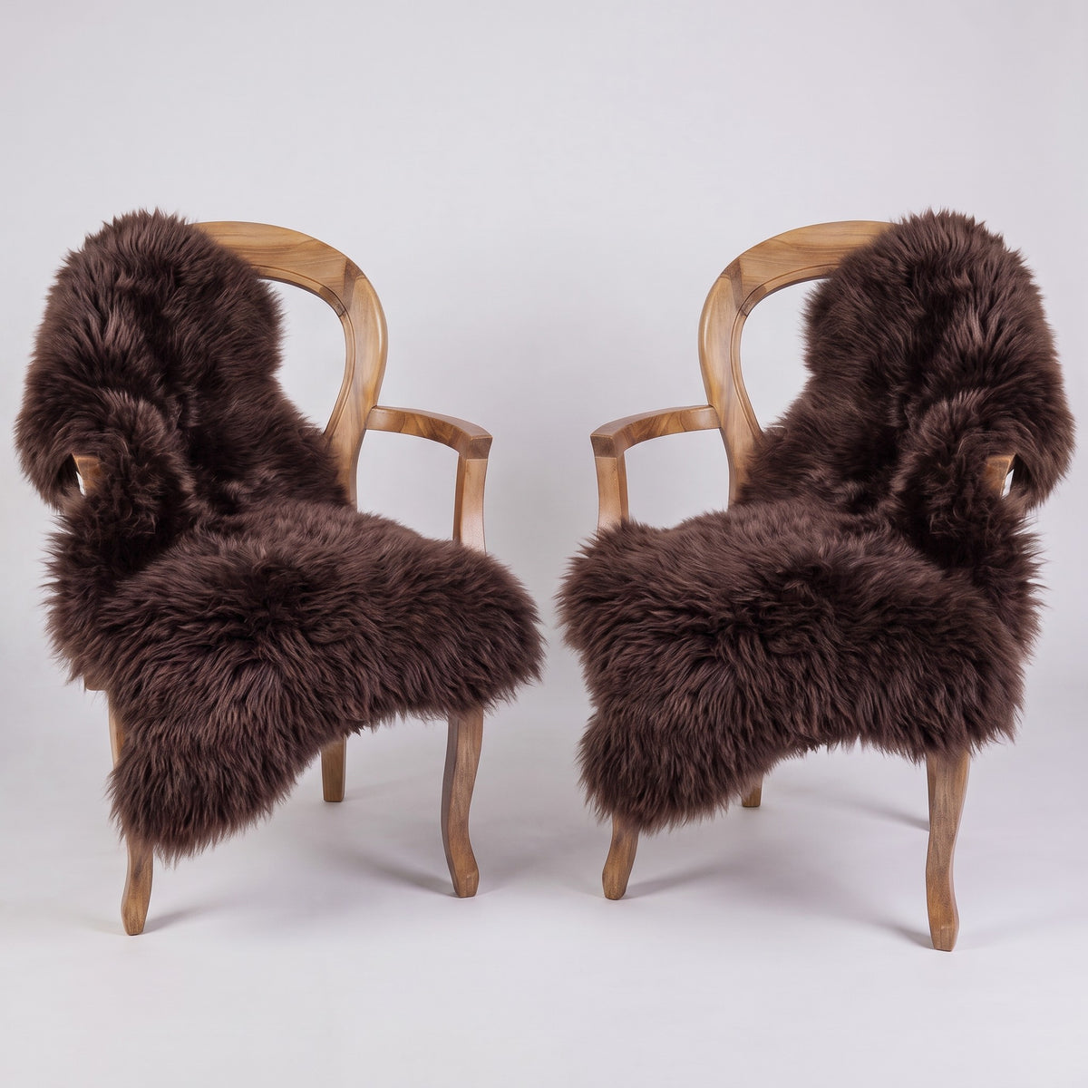 Pair of Chocolate X-Large single sheepskin rugs draped over two armchairs