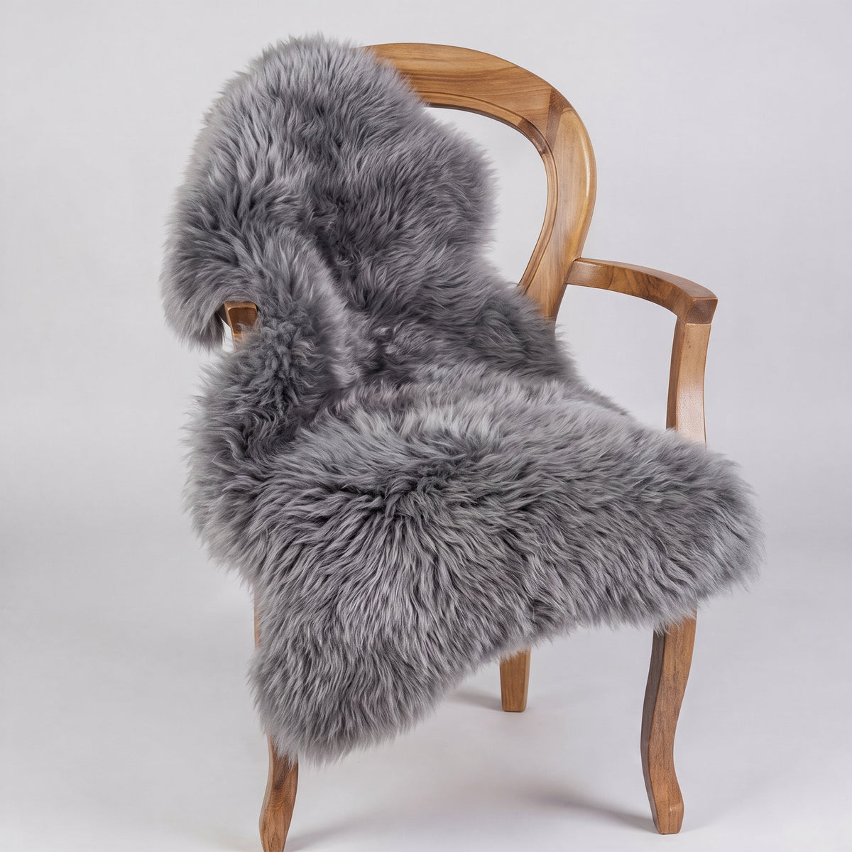 Grey X-Large single sheepskin rug draped over a wooden armchair, one of the pair