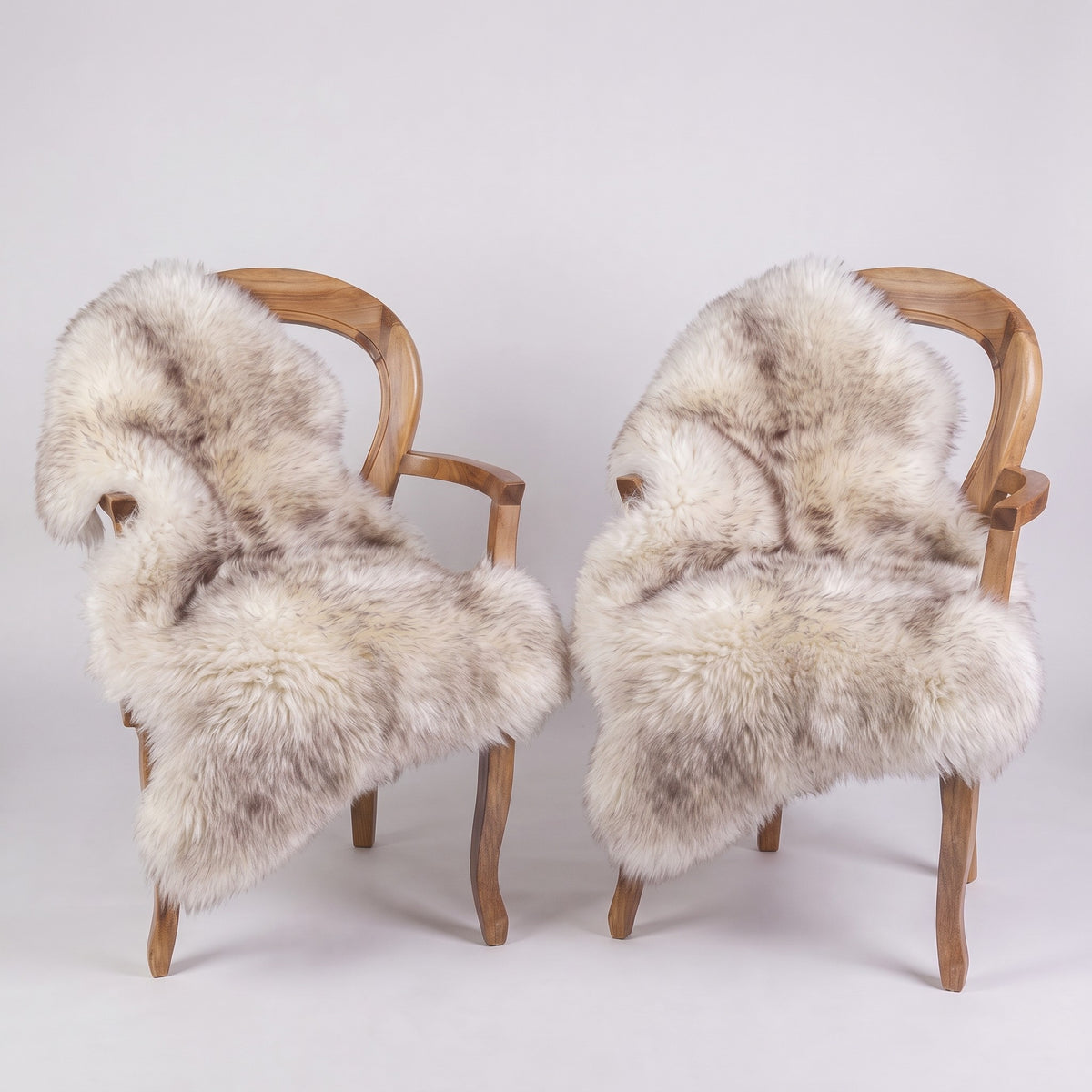 Pair of Wolf Tip X-Large single sheepskin rugs draped over two armchairs