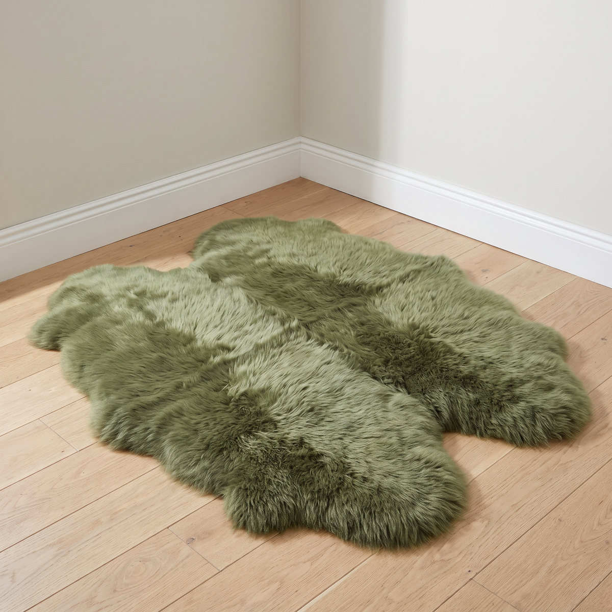 Quad New Zealand Sheepskin Rug & Throw in Apple Green (Meadow) on wood floor