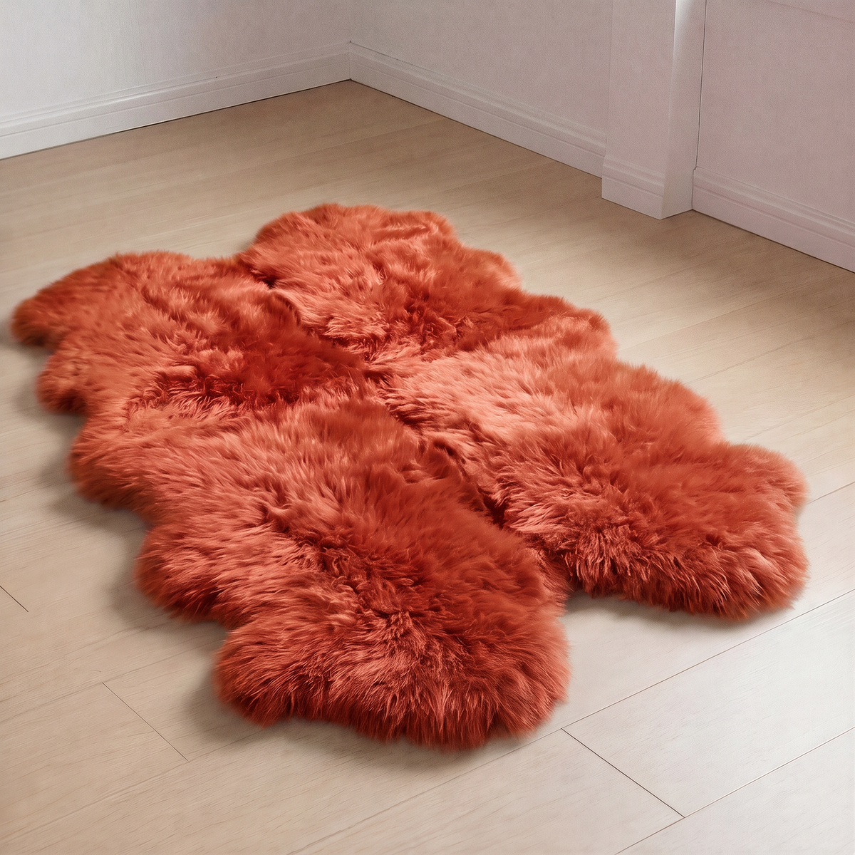Quad New Zealand Sheepskin Rug & Throw in Burnt Orange on wood floor
