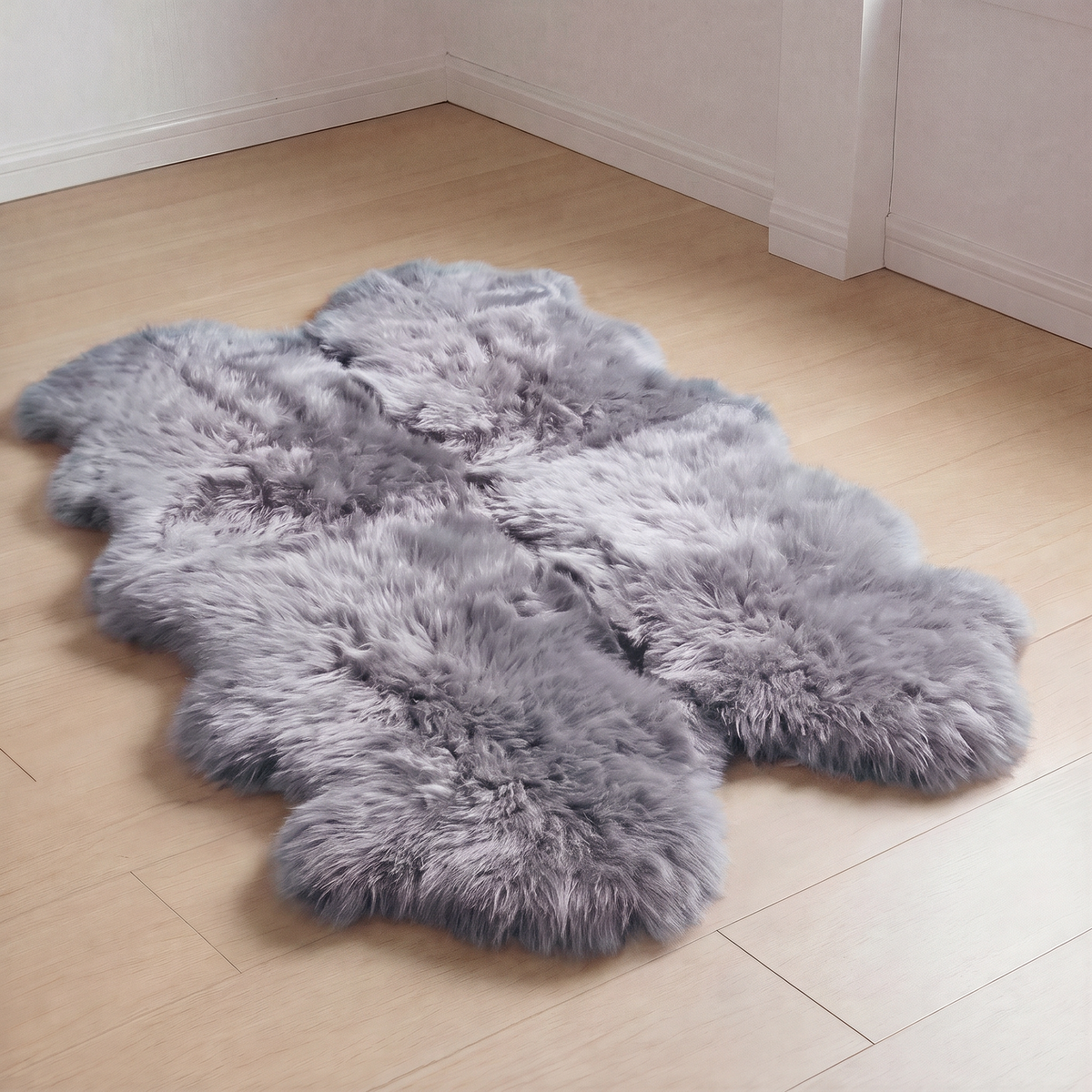 Quad New Zealand Sheepskin Rug & Throw in Grey Mist on wood floor