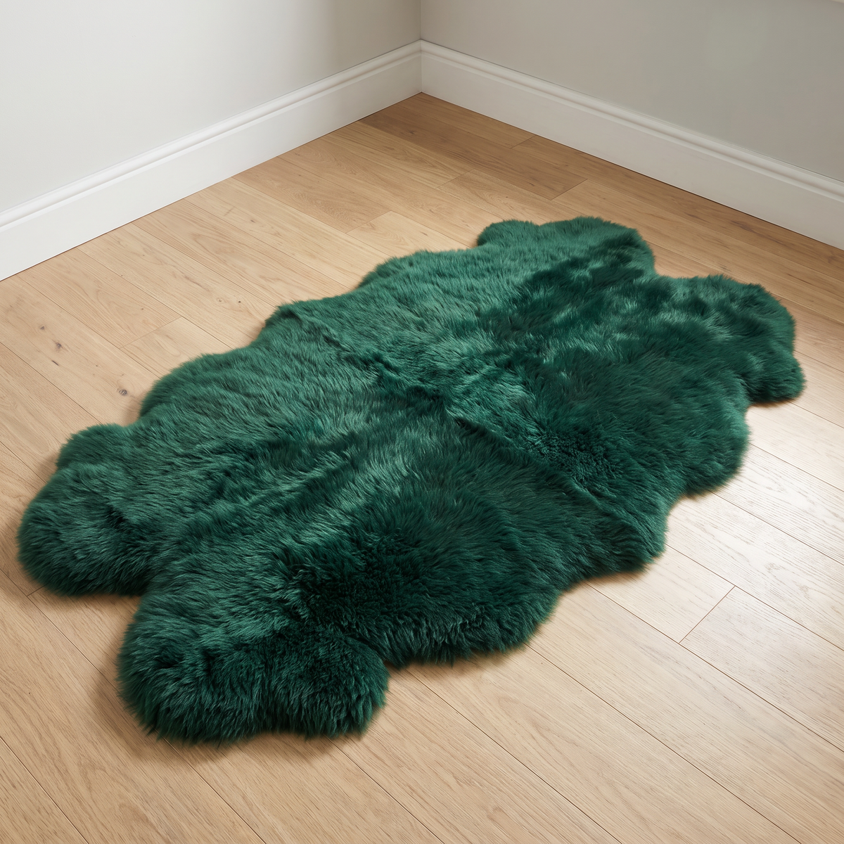 Quad New Zealand Sheepskin Rug & Throw in Jungle Green on wood floor