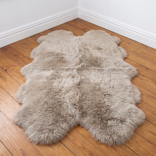 Light Grey quad New Zealand sheepskin rug, warm greige wool, L180 x W105 cm, on a wooden floor