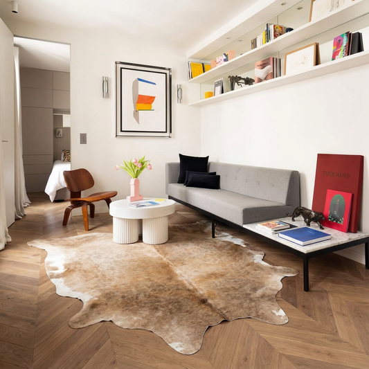 Natural cowhide rug styled on the floor of an editorial interior room