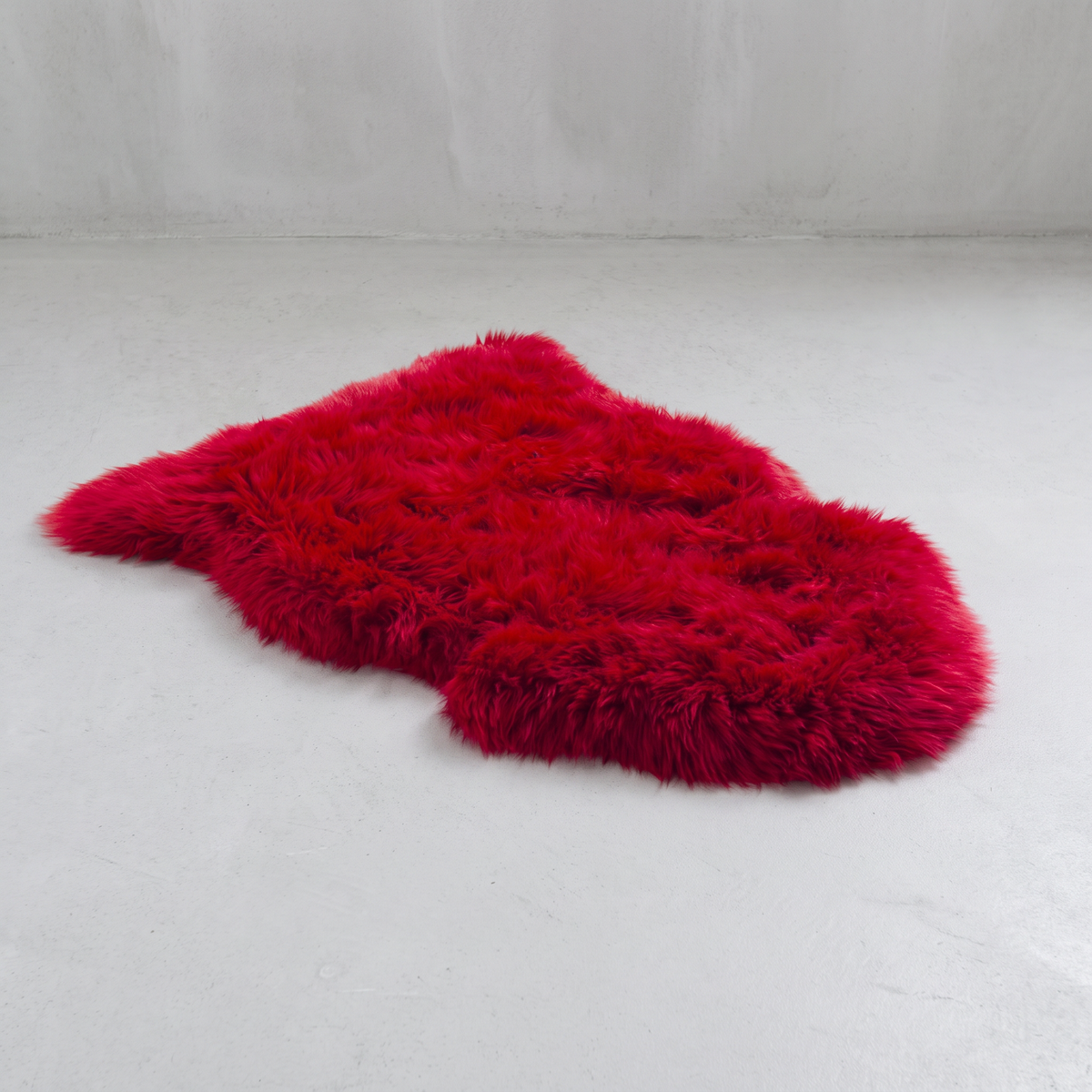 Wildfire red single sheepskin rug laid flat on a pale grey floor