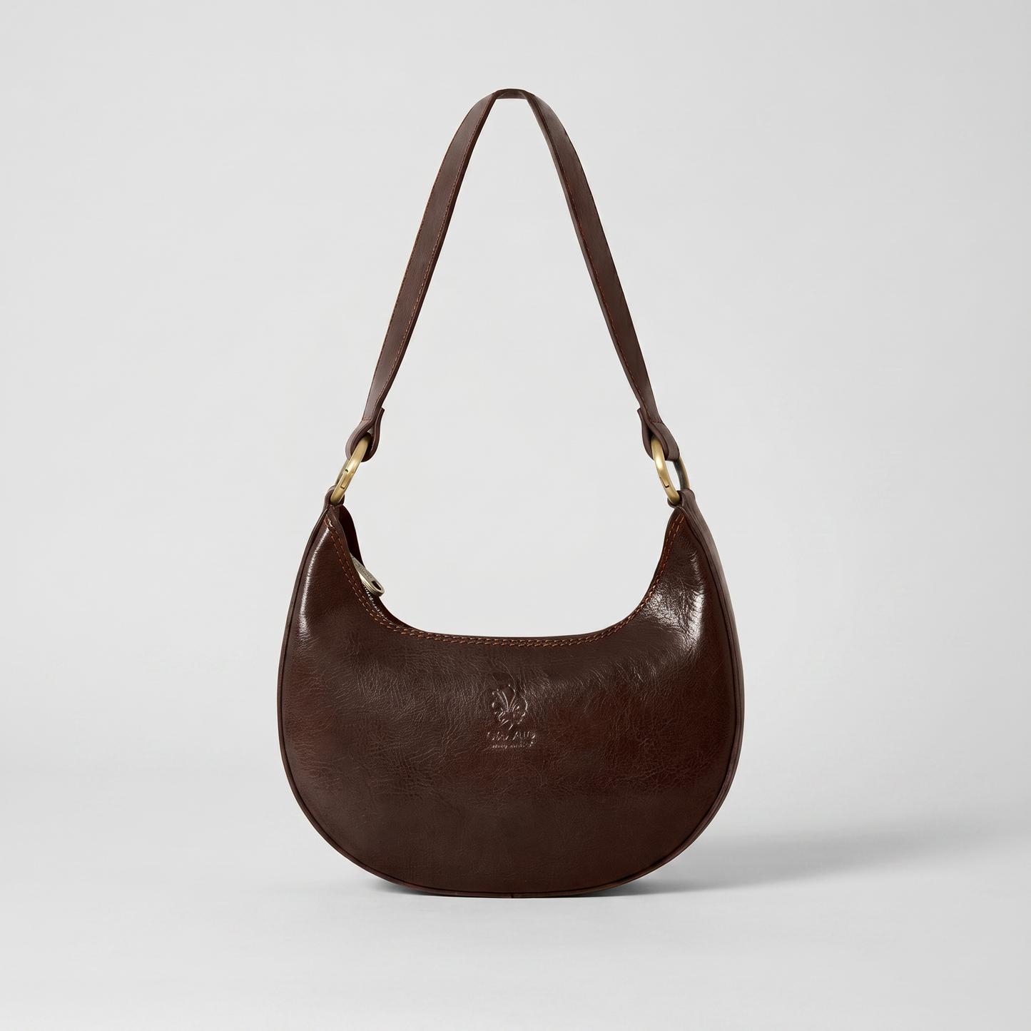 Mezzaluna leather shoulder bag in Dark Chocolate on light grey studio background