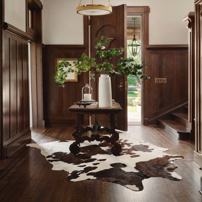 Caramel and ivory exotic printed cowhide rug styled on the floor of an editorial interior