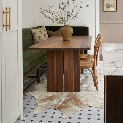 Caramel and ivory exotic printed cowhide rug styled on the floor of an editorial interior