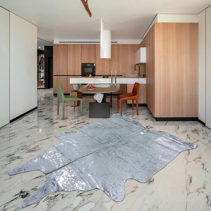 Silver on off-white metallic cowhide rug styled on the marble floor of a modern minimal kitchen-dining room